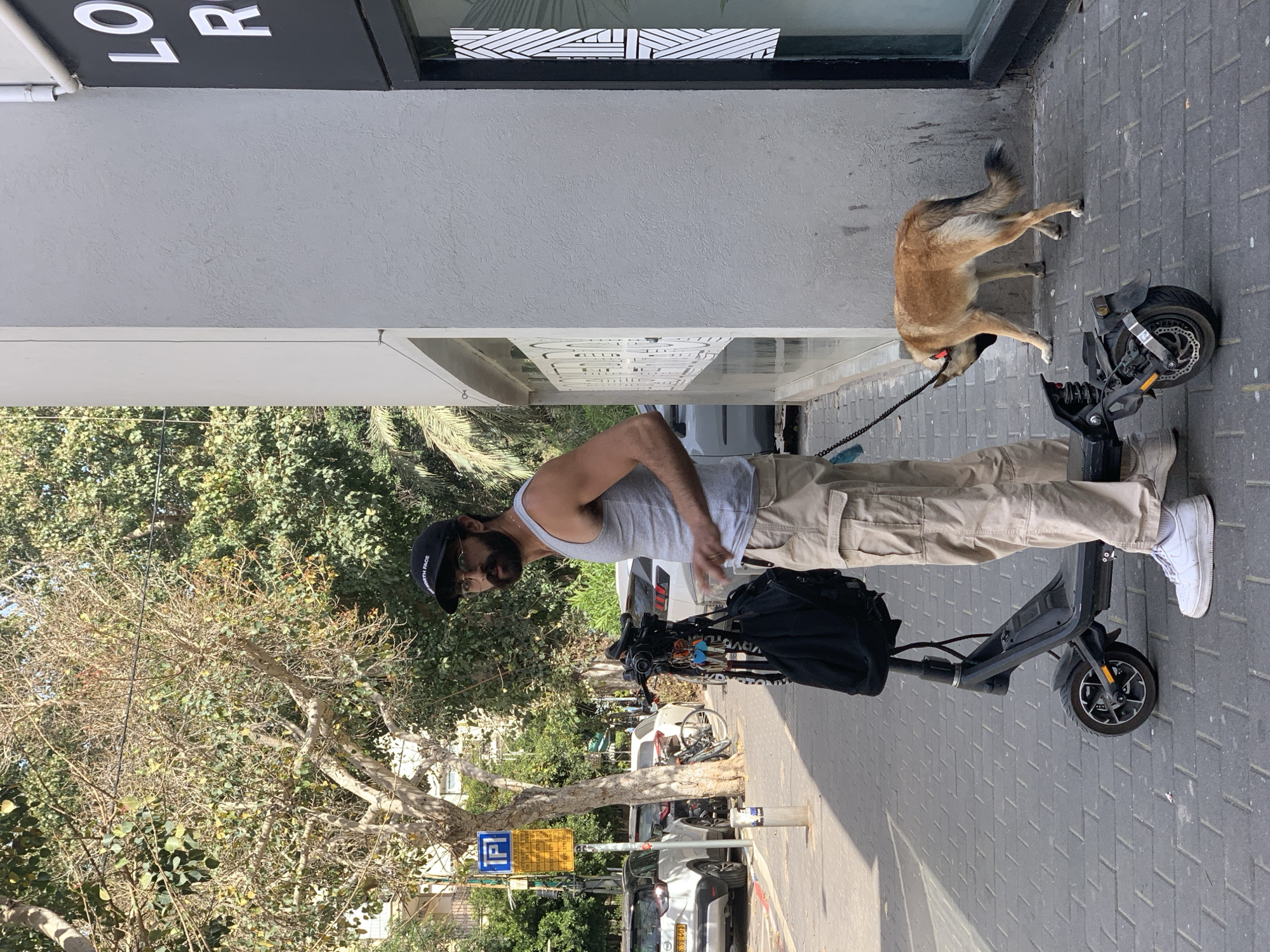 Man with dog and scooter spotted on Tel Aviv sidewalk