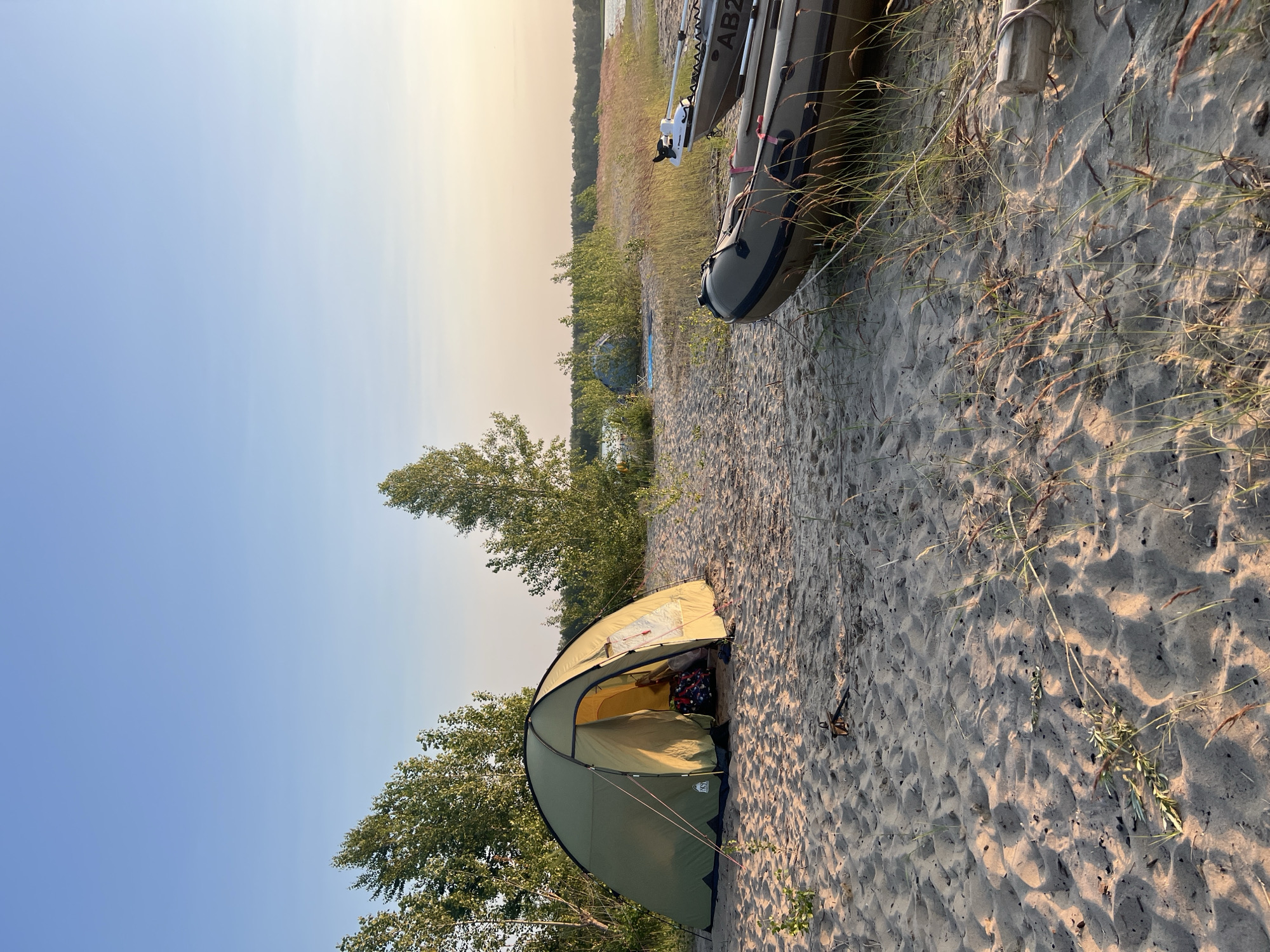 Tent and inflatable boats on a sandy beach near Borovoe