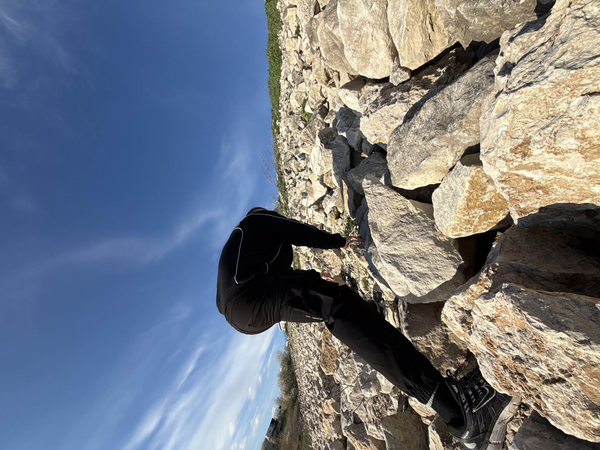 Person climbs rocks, rests by lake in Shumen