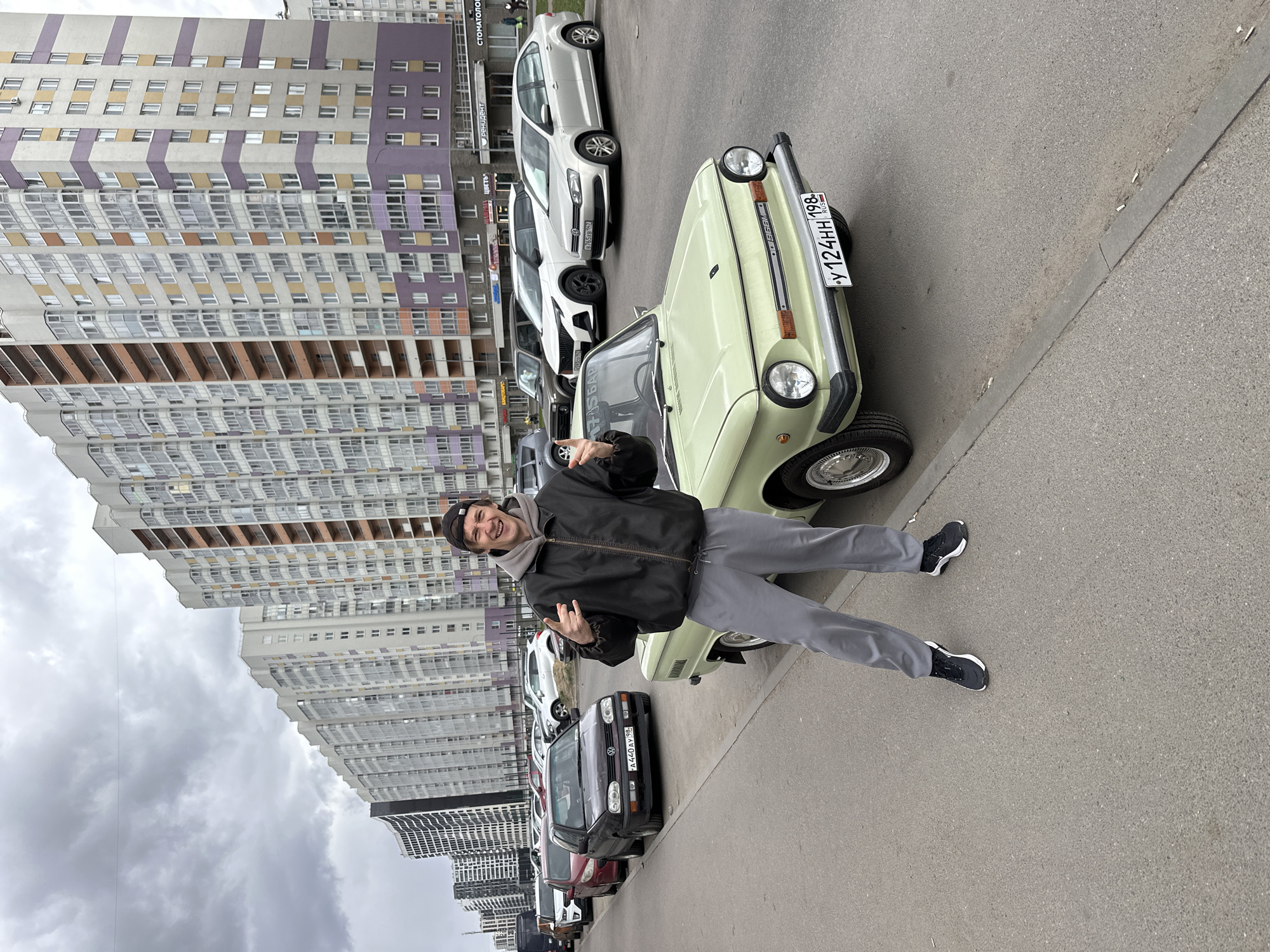 Man poses with vintage green car in Murino