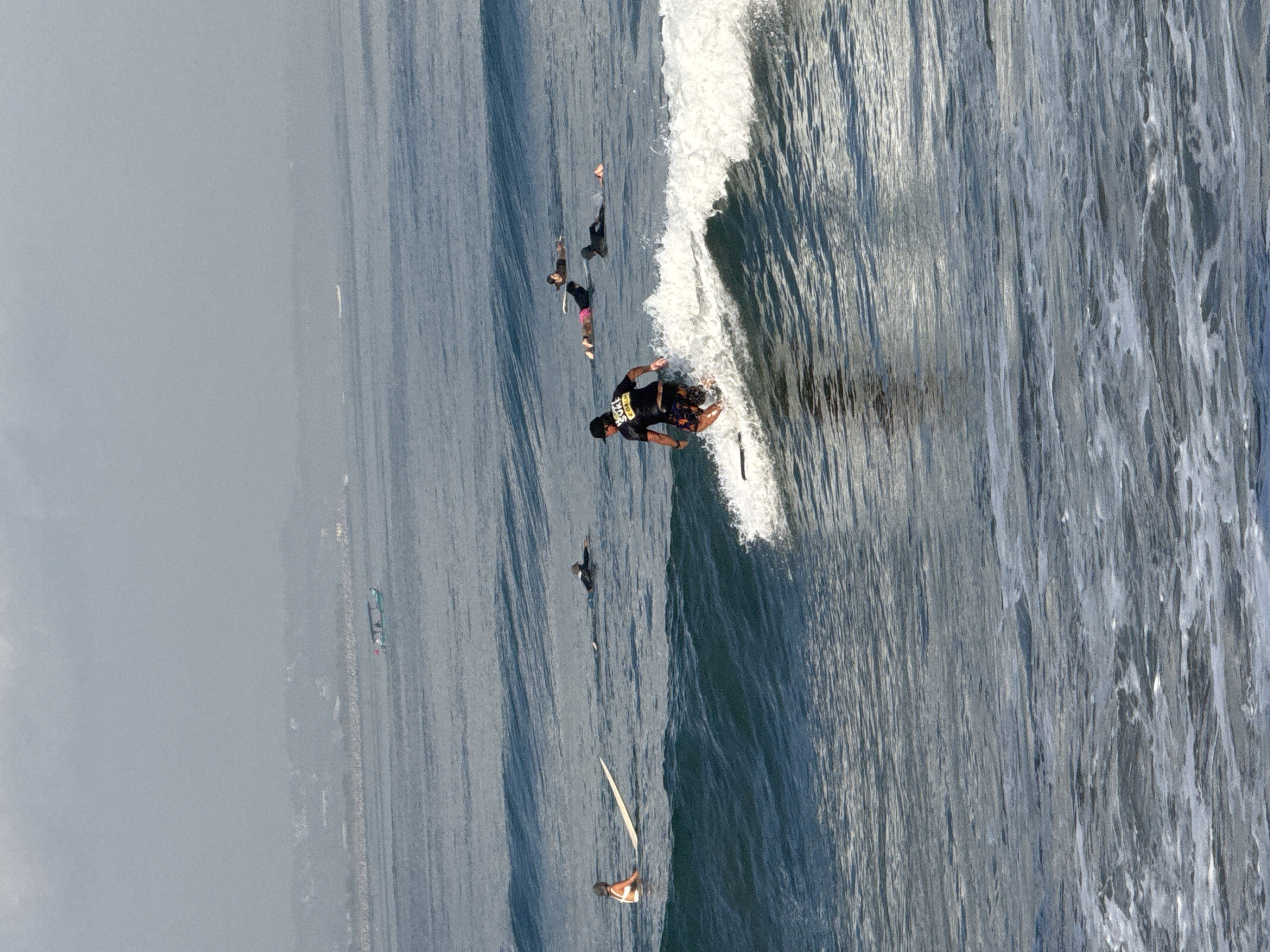 Busy surf session on a hazy morning at Kuta Beach