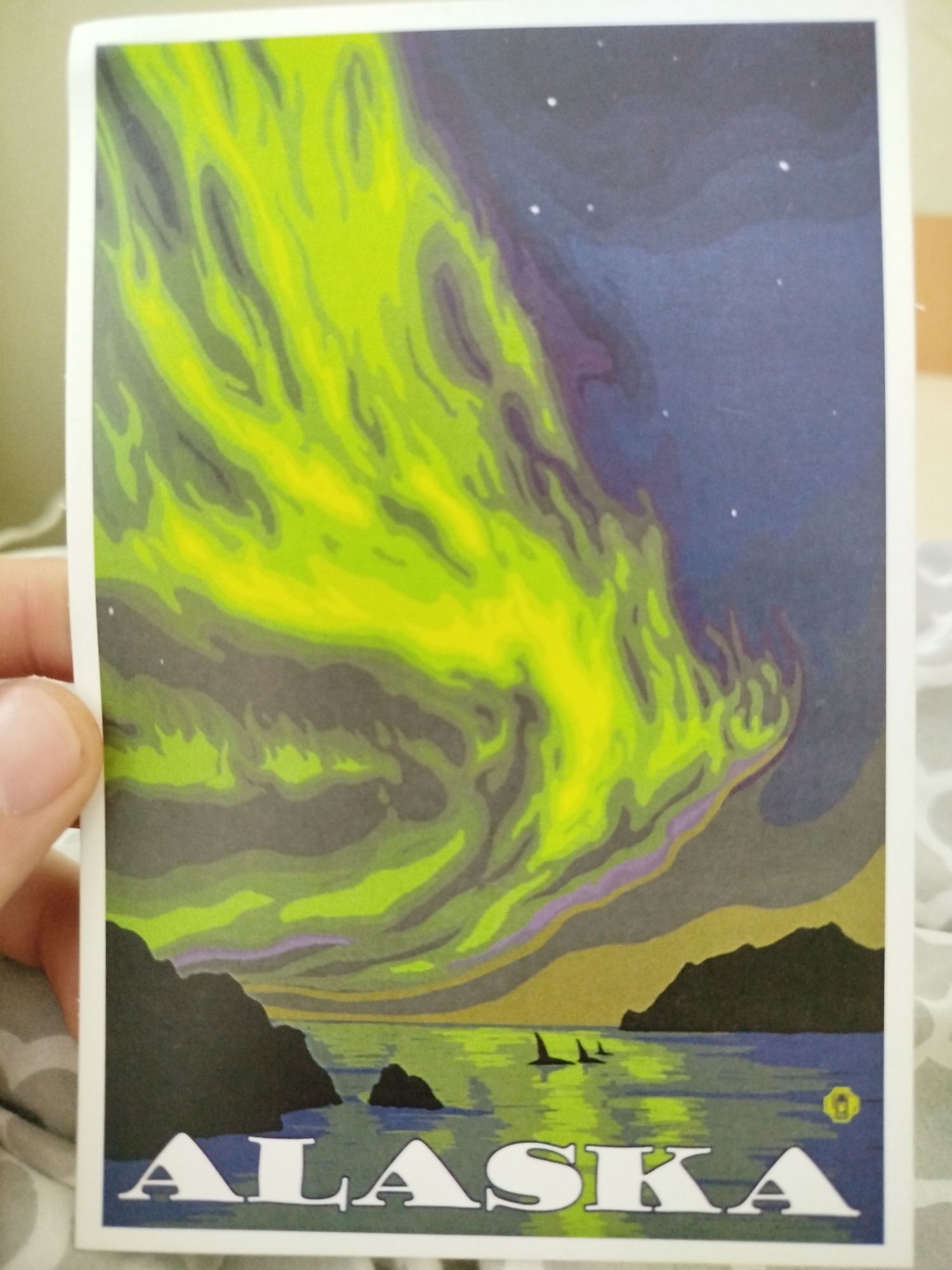 Person holds Alaska aurora postcard in Varna, Bulgaria