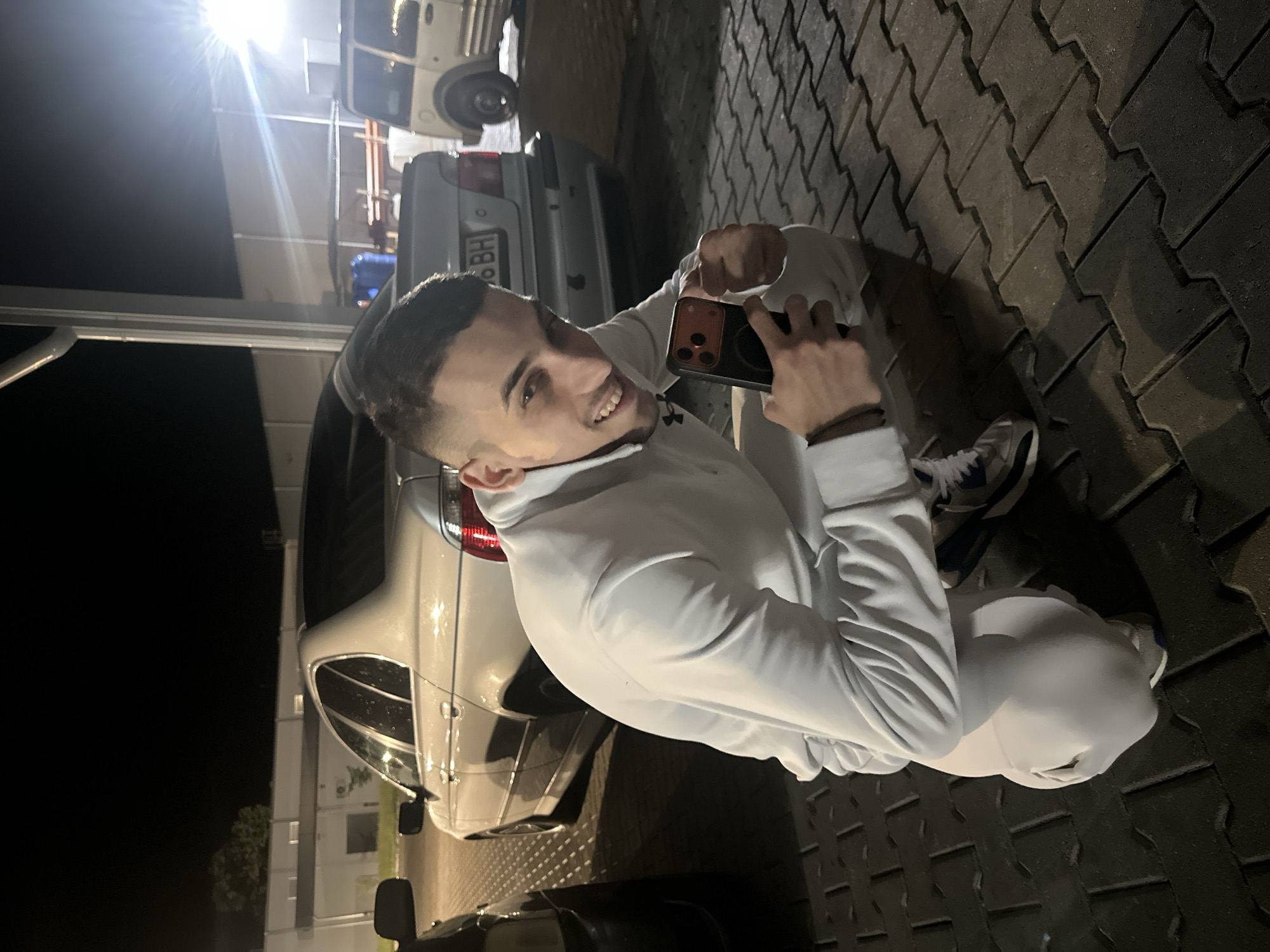 Young men gather for nighttime photo session in commercial area