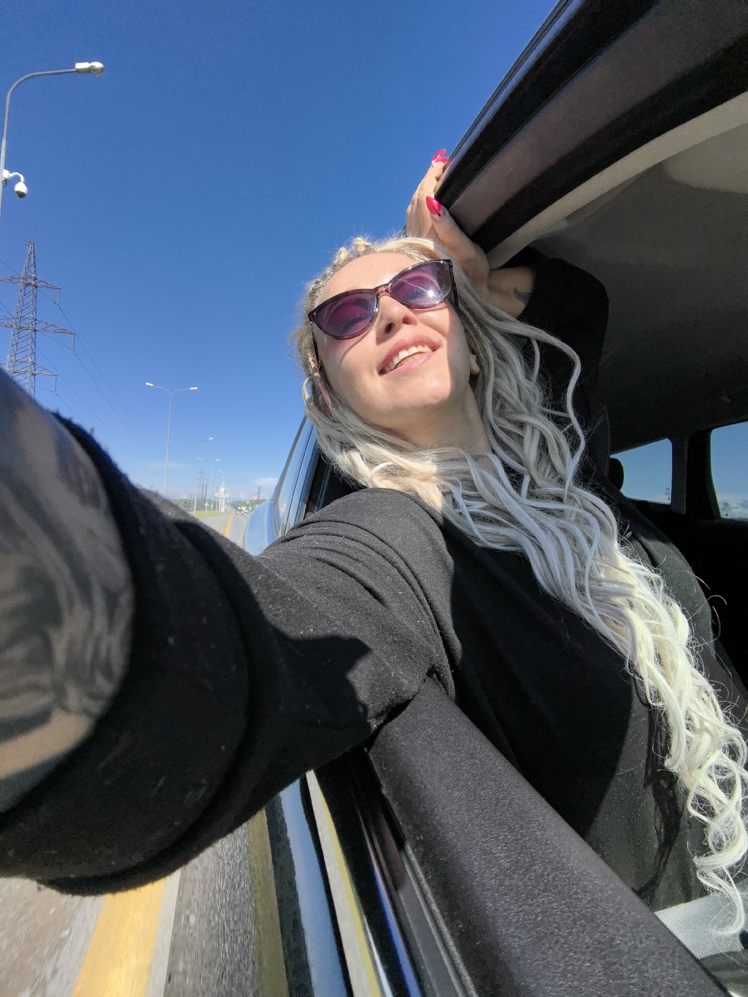 Hanging out a car window on a sunny Russian summer drive