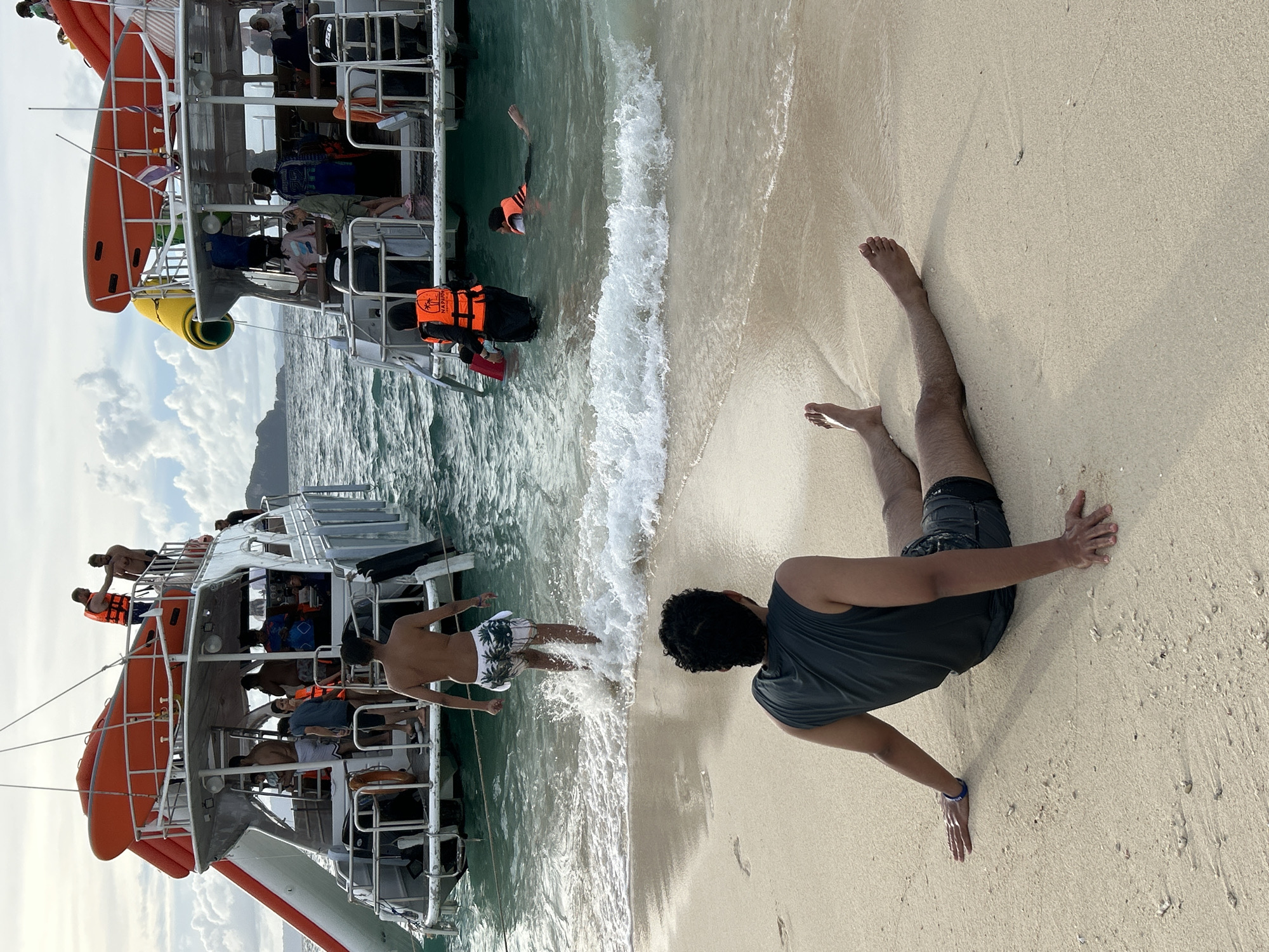 Boats, beach, and swimmers at Phru Nai's shoreline