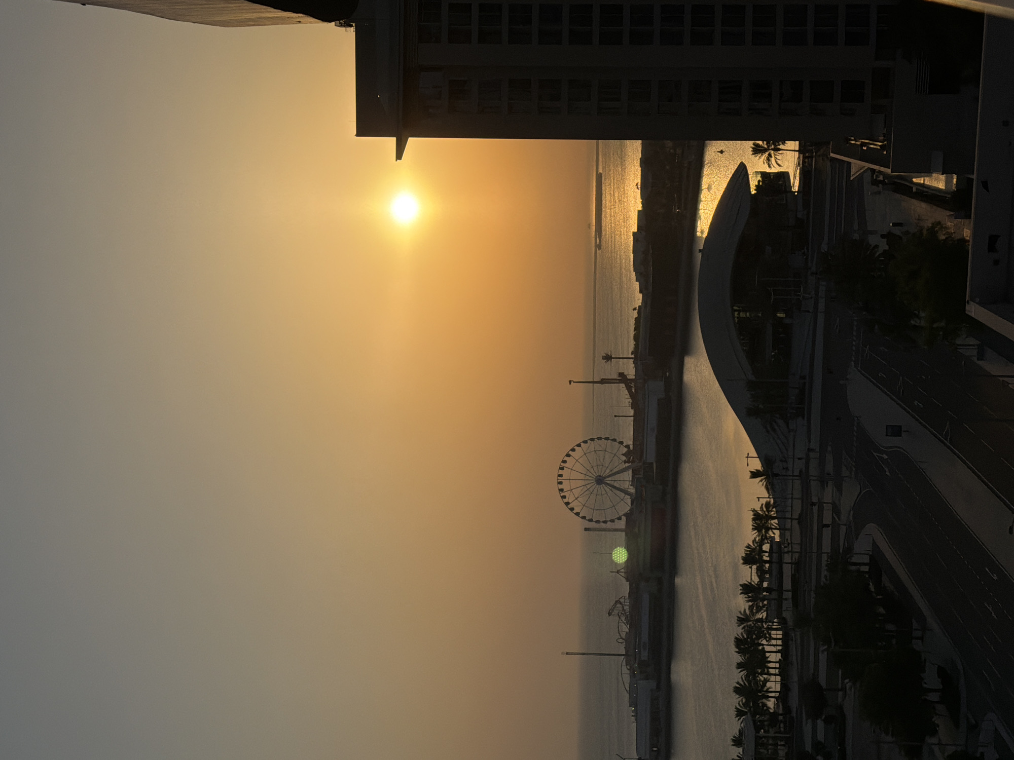 Golden sunset hits Lusail's waterfront pier and Ferris wheel