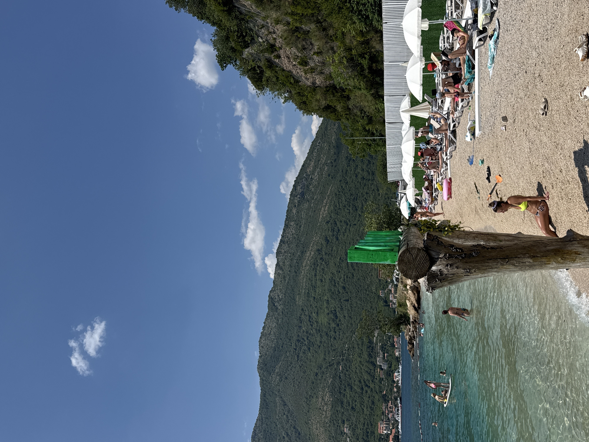 Sunny bay day: boats, paddleboards, and a hillside coastal town