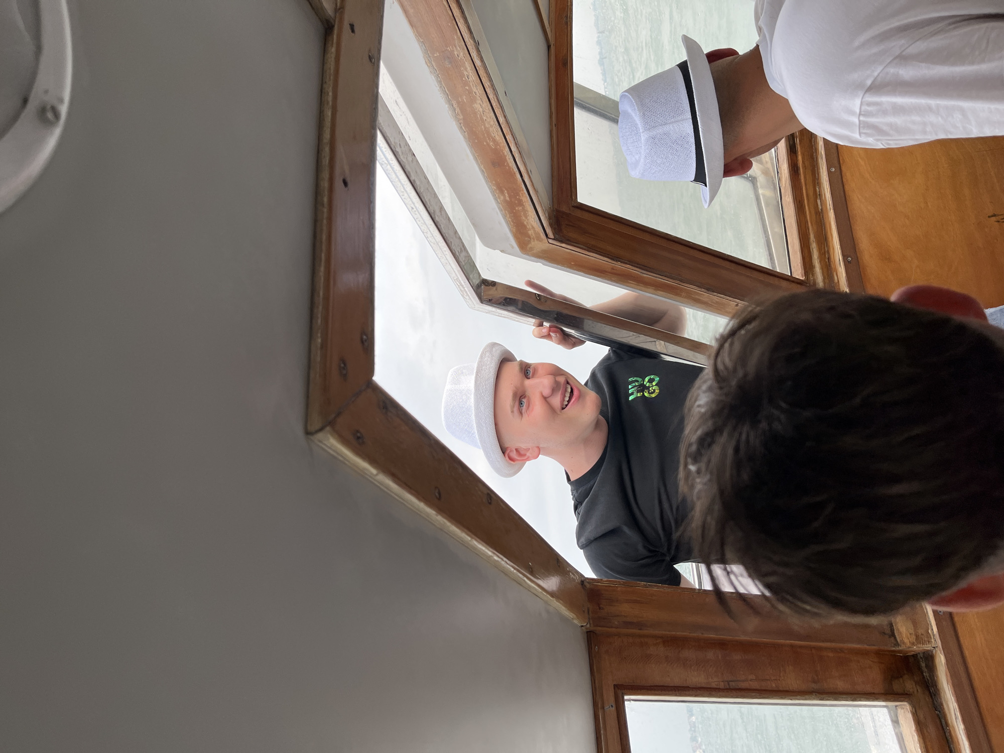 Tourists photograph from boat cabin during Venice excursion