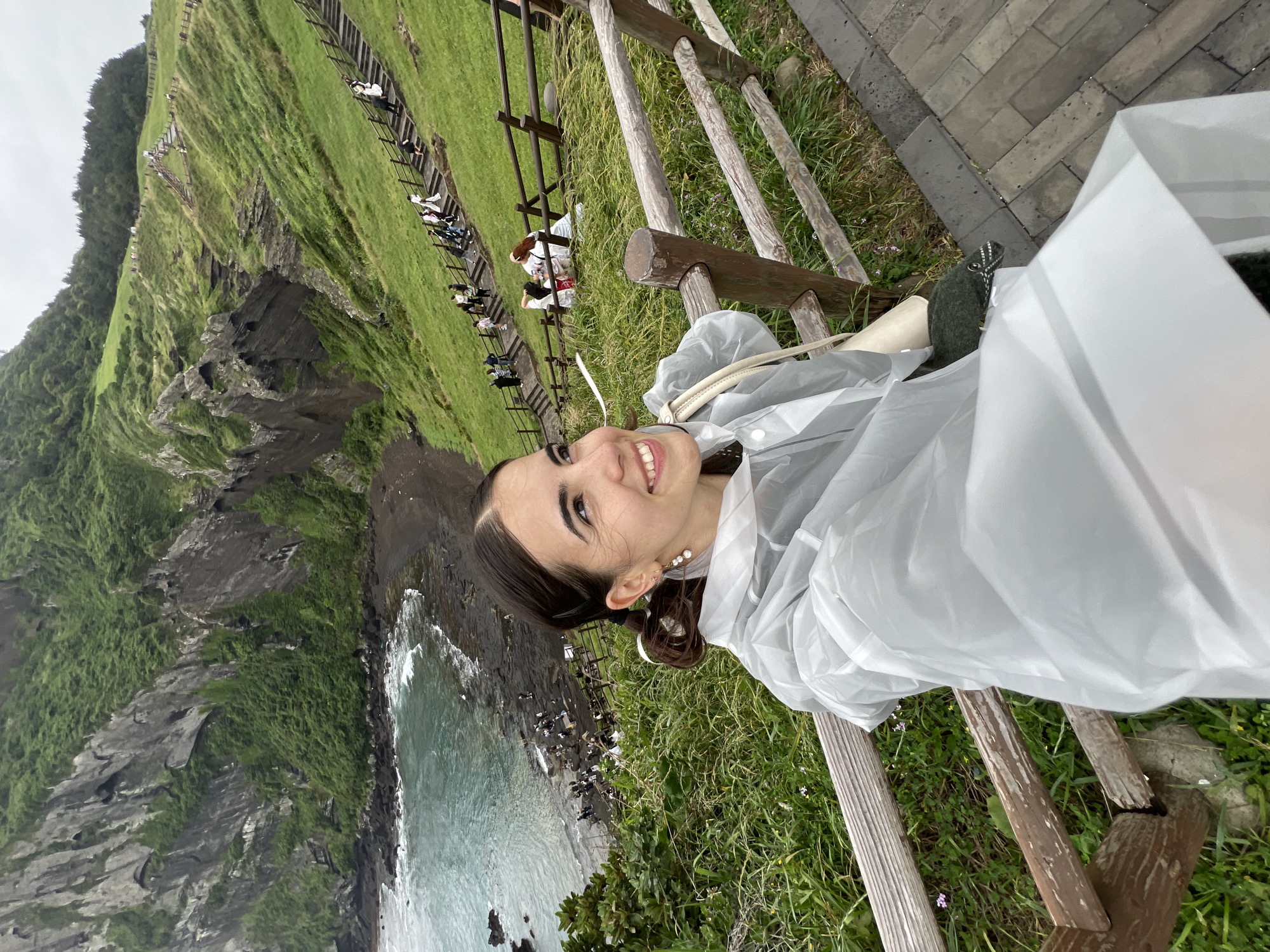 Woman takes selfies at Seogwipo coastal viewpoint early morning