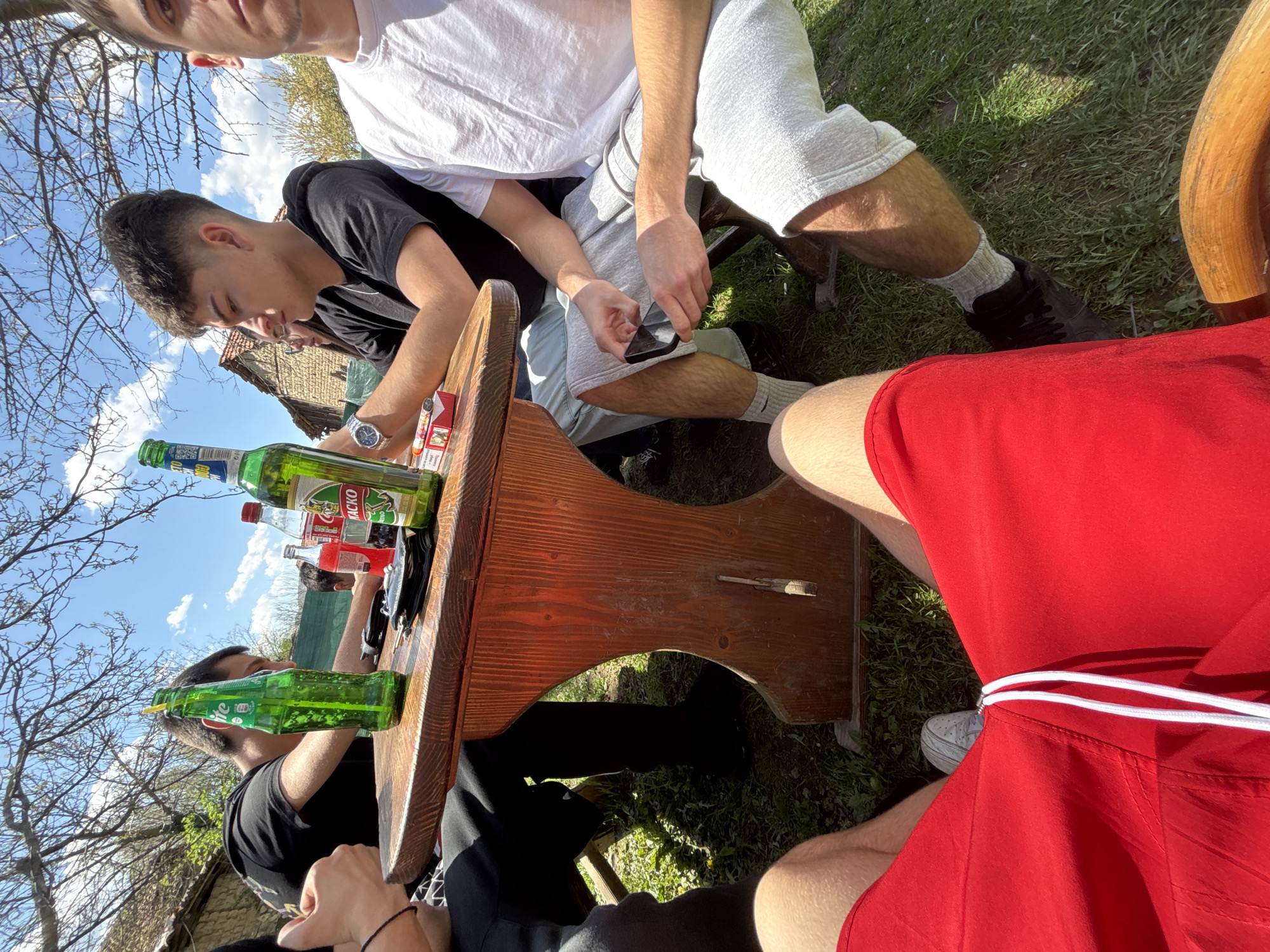 Outdoor gathering observed around wooden table in Dabene, Bulgaria