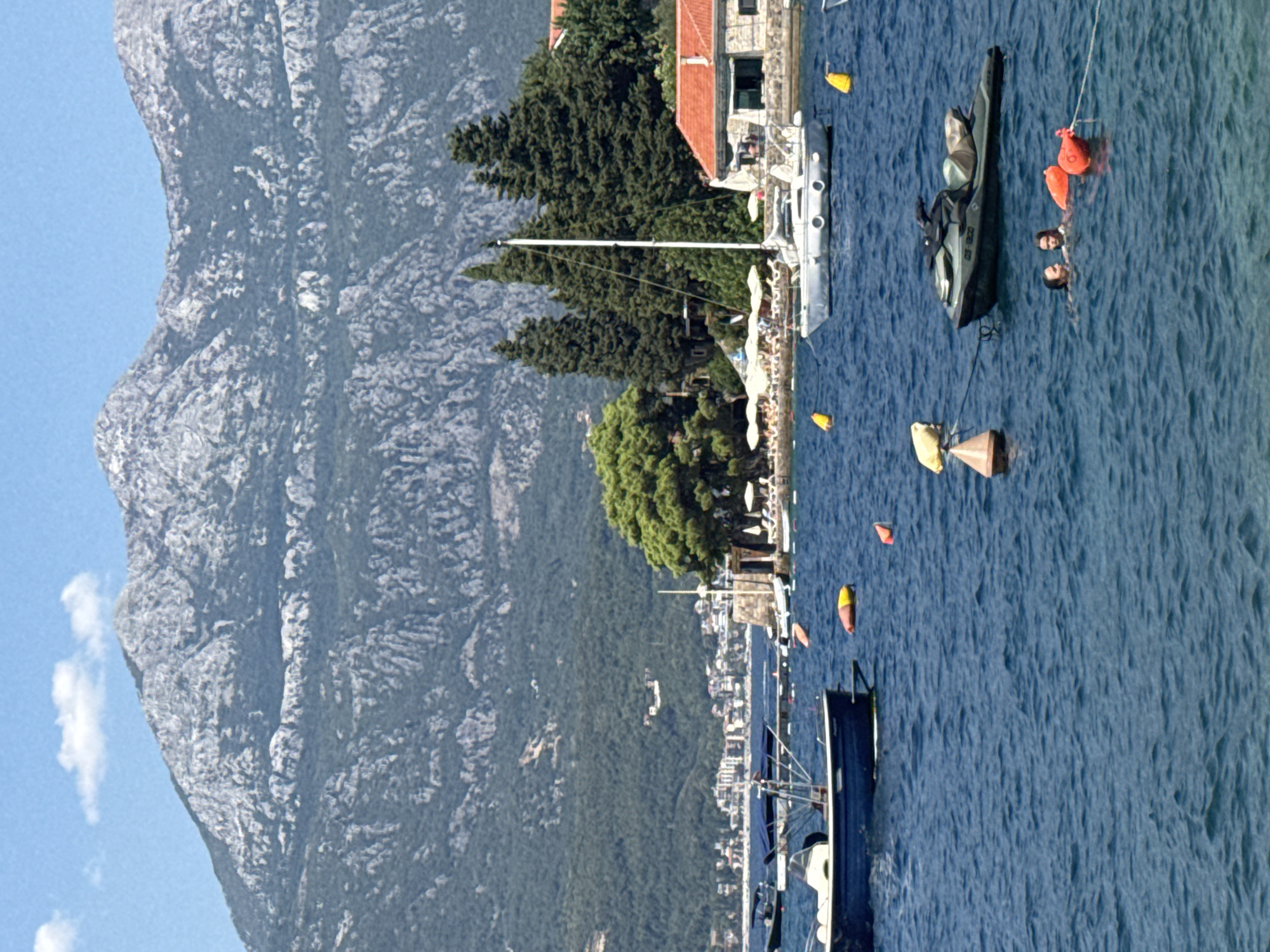Lazy afternoon at a sunny coastal bay with boats and water play