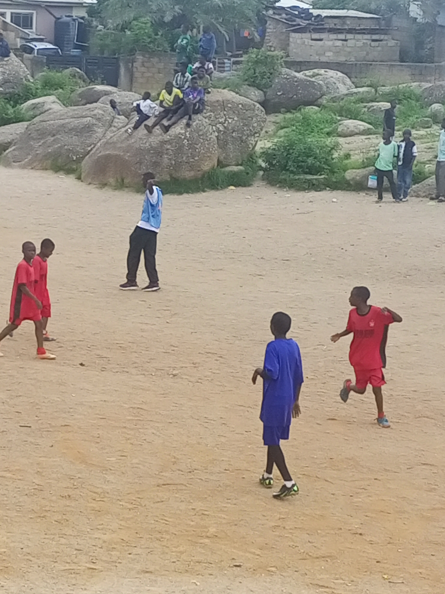 Pickup soccer on a rocky dirt field in Jos, Nigeria