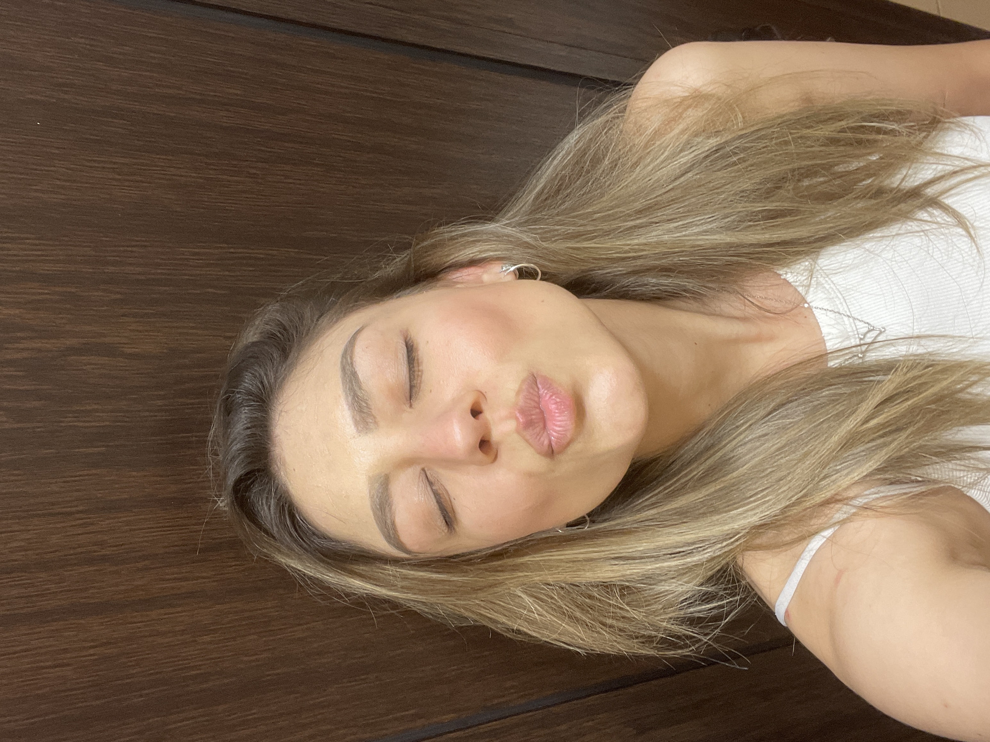 Woman photographed making kissing face, exhaling vapor in evening