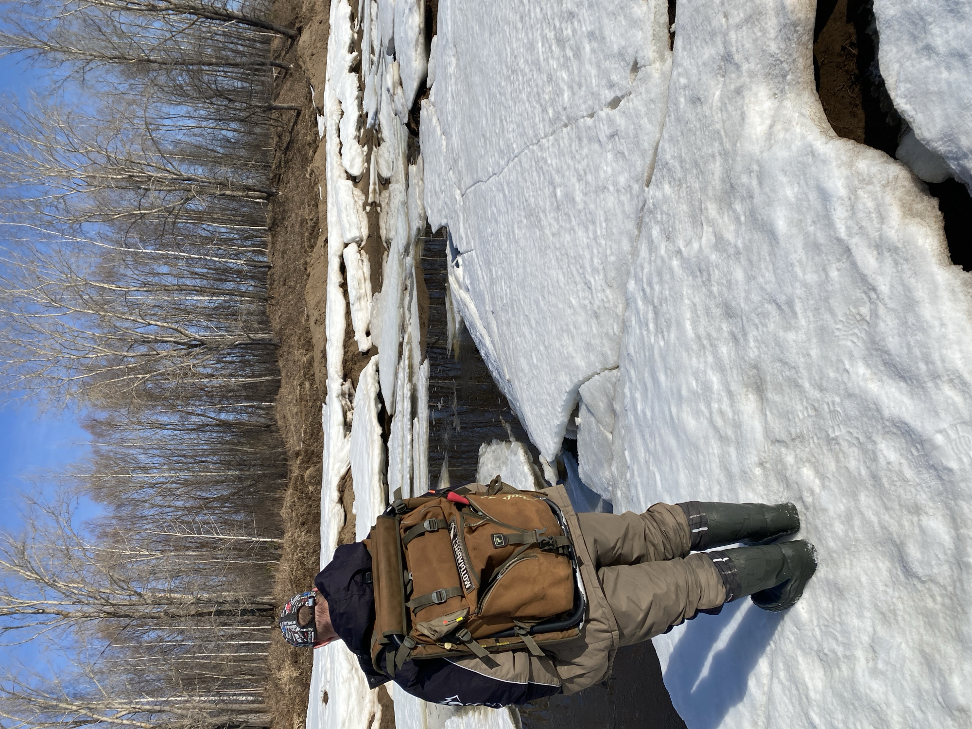 Winter hiker crosses cracked ice in rural Russia