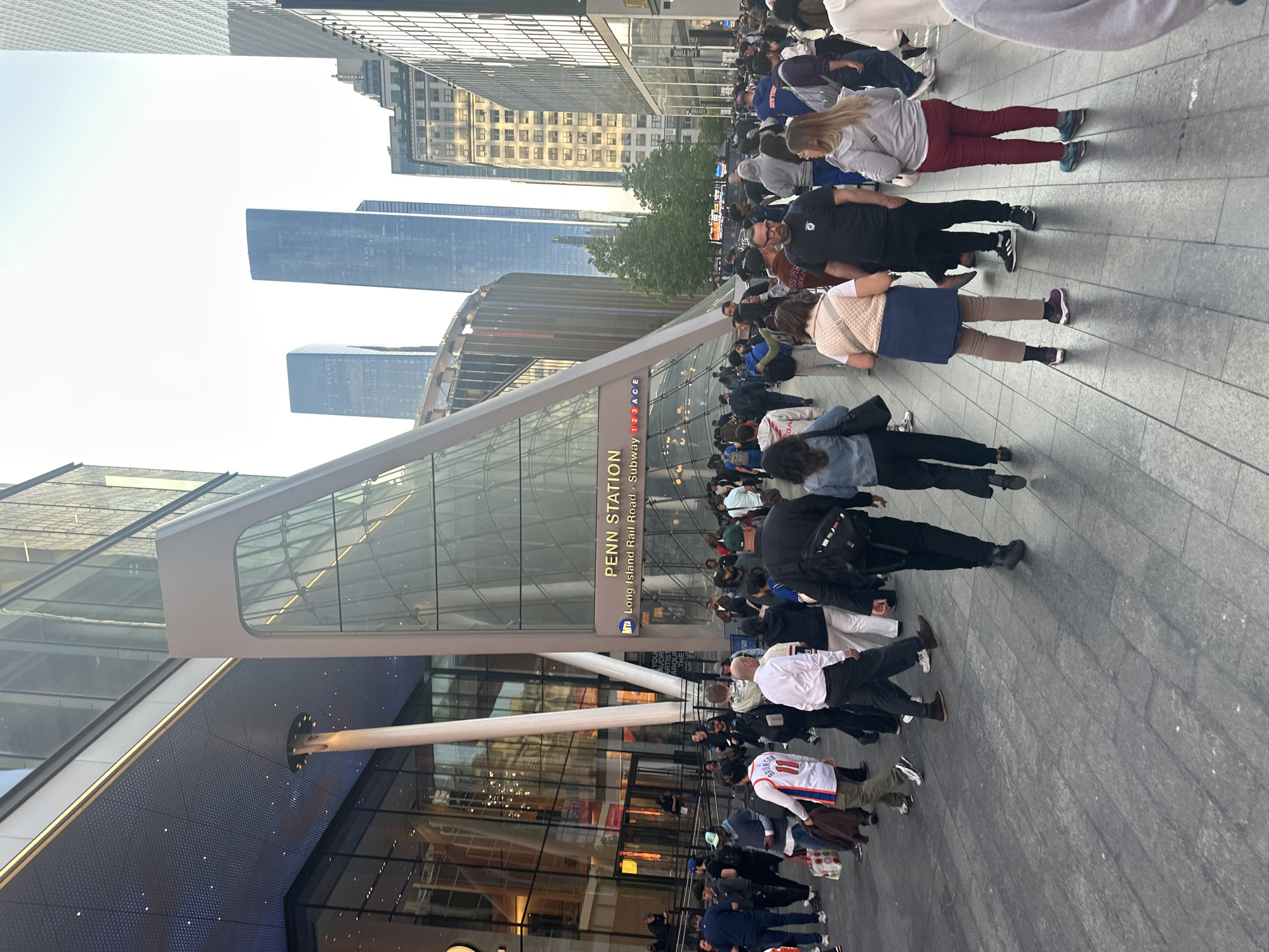 Crowd gathers at modern NYC building with digital displays