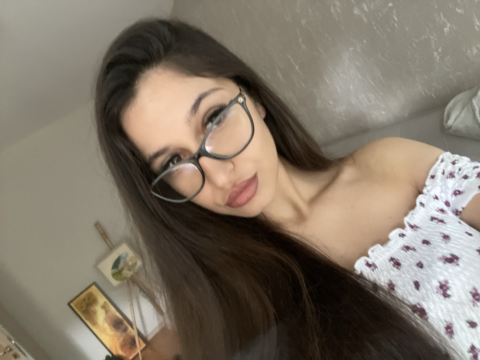 Indoor selfie session on a light couch, floral top