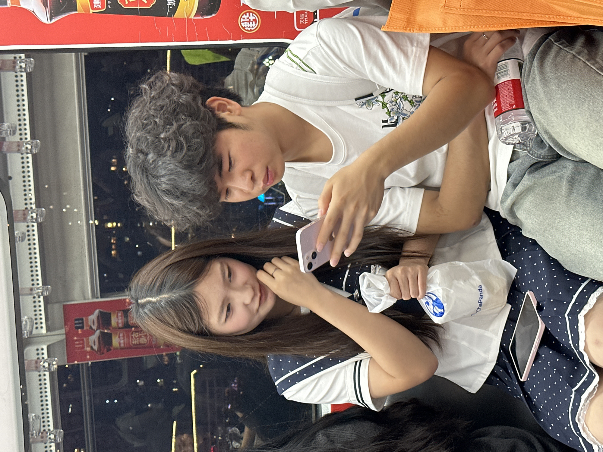 Young couple uses phones on public transit in Chongqing