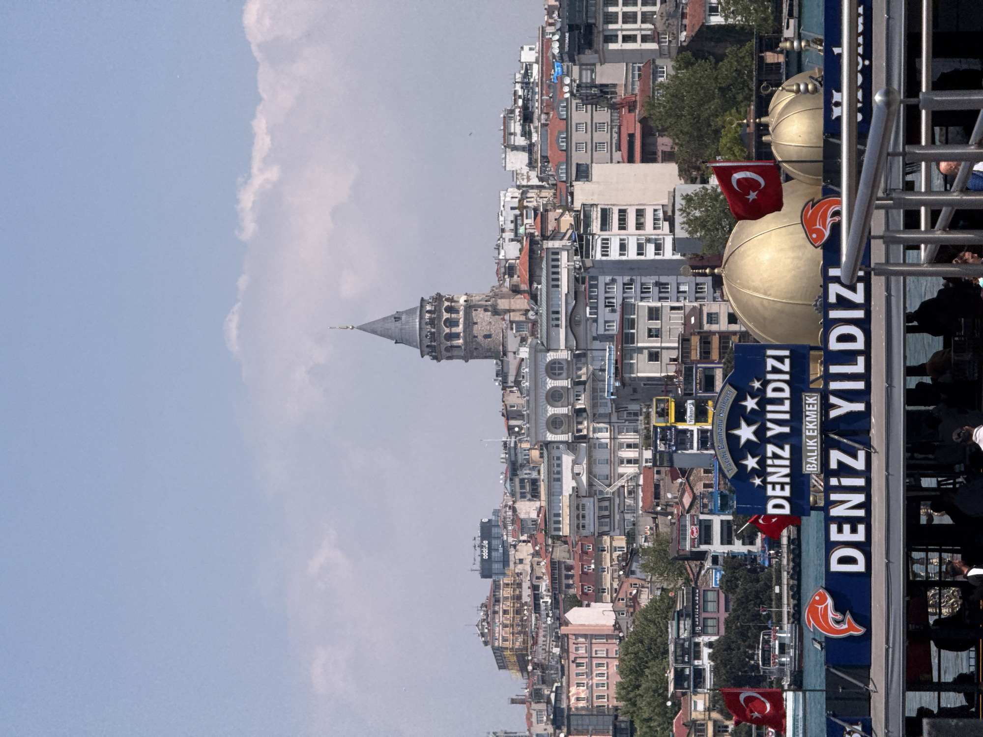 Morning views of Istanbul's Galata Tower captured from water, bridge