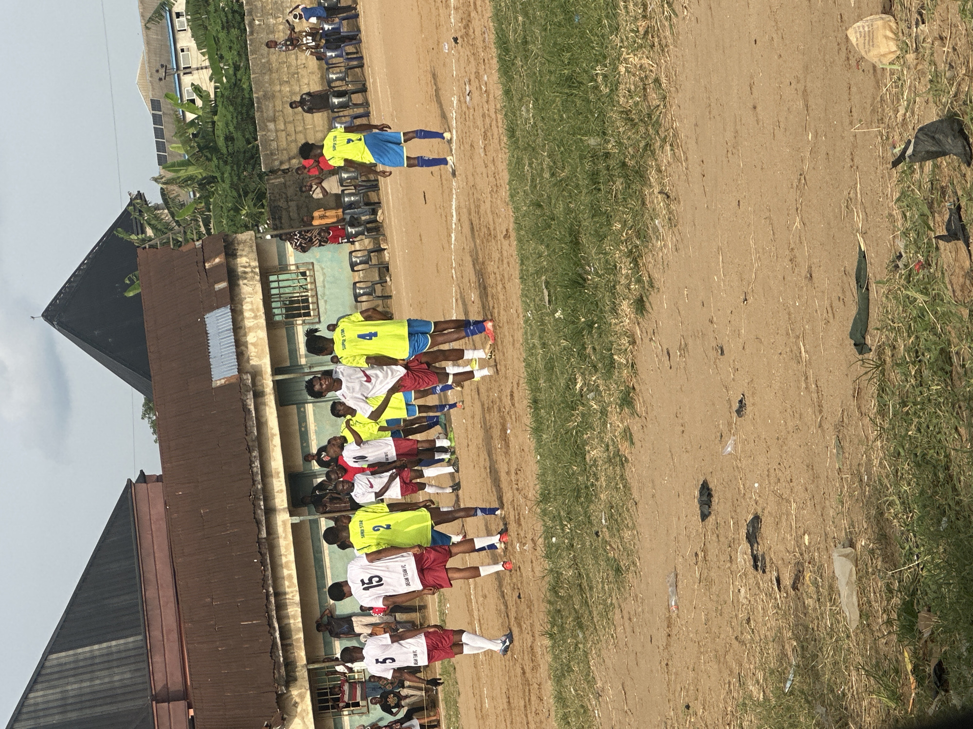 Soccer players gather on dirt field in Umuode, Nigeria