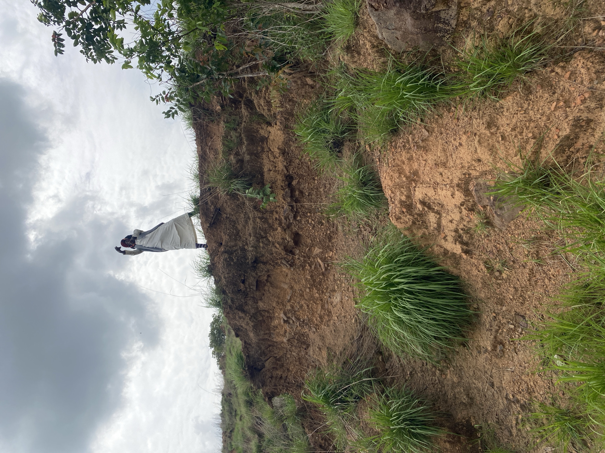 Person traverses steep hillsides in rural Nigeria countryside