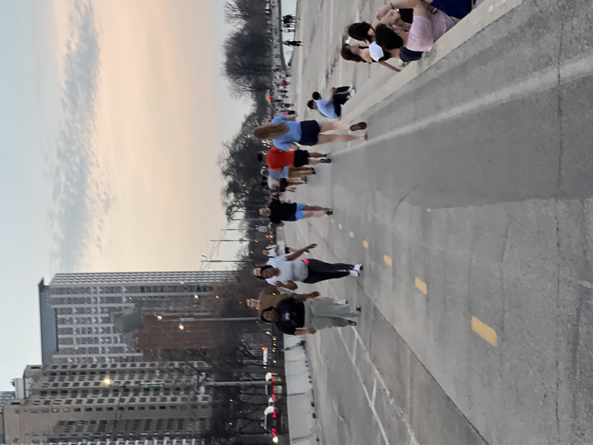 Group walks on Chicago street under overcast sunset sky