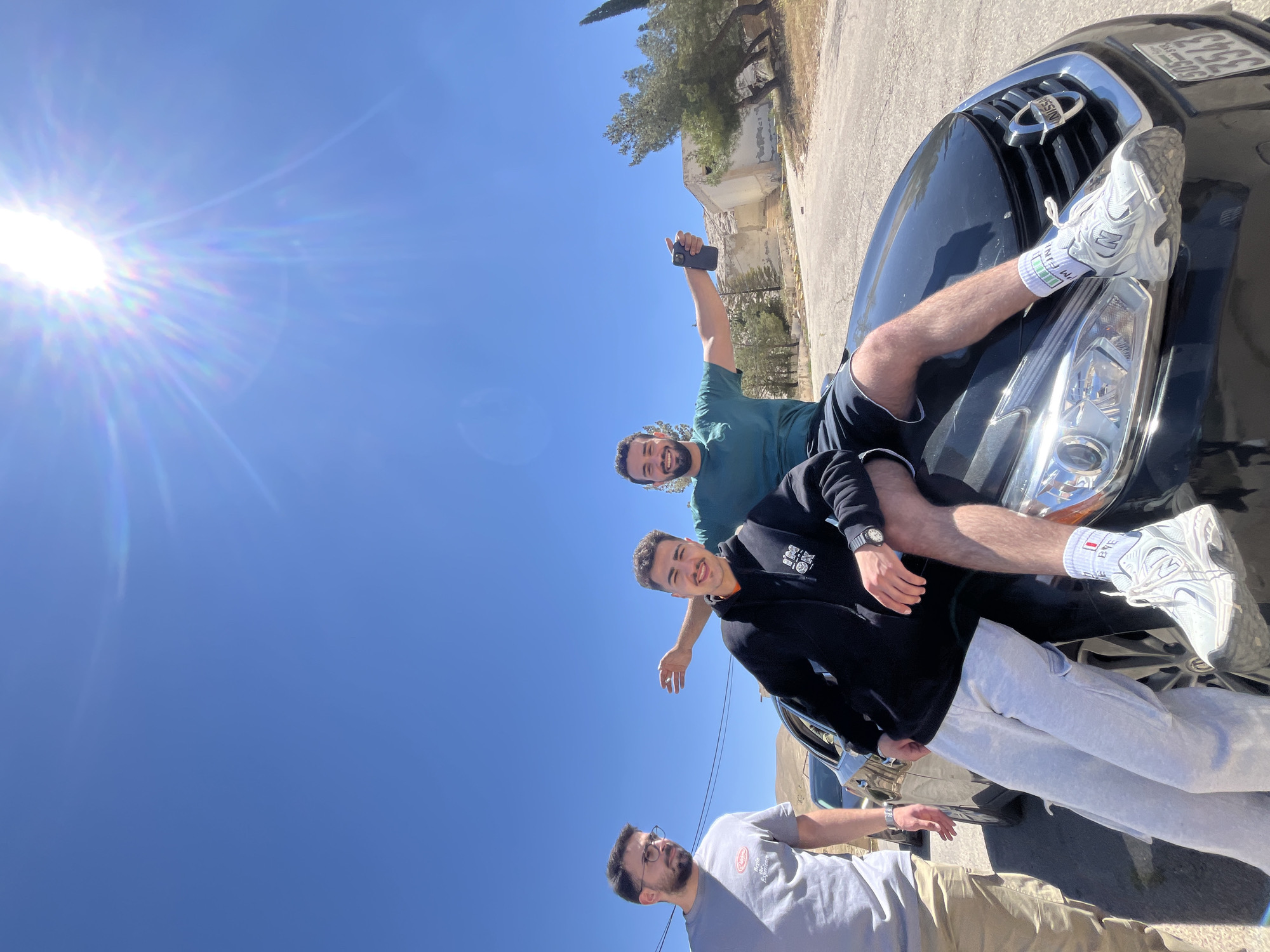 Young men pose with car in Ma'loula, Syria