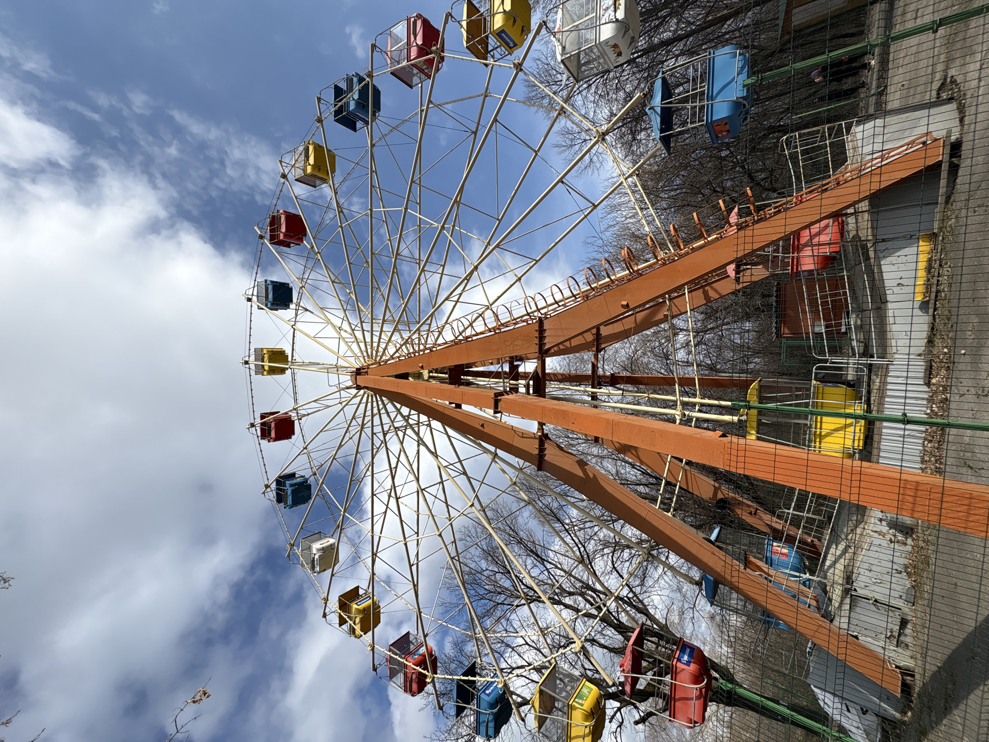 Colorful Ferris wheel operates under blue skies in Ulyanovsk