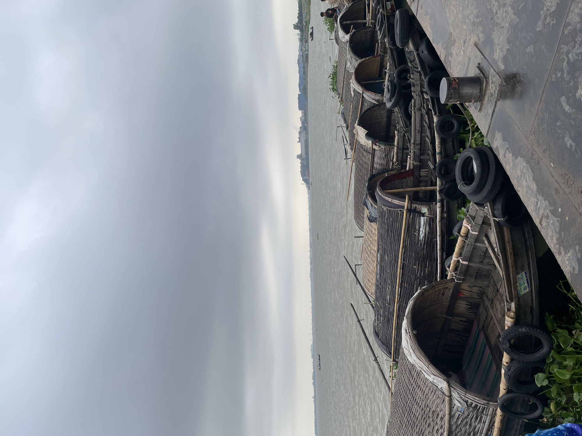 Traditional passenger boats docked at Sonargaon waterfront during cloudy night