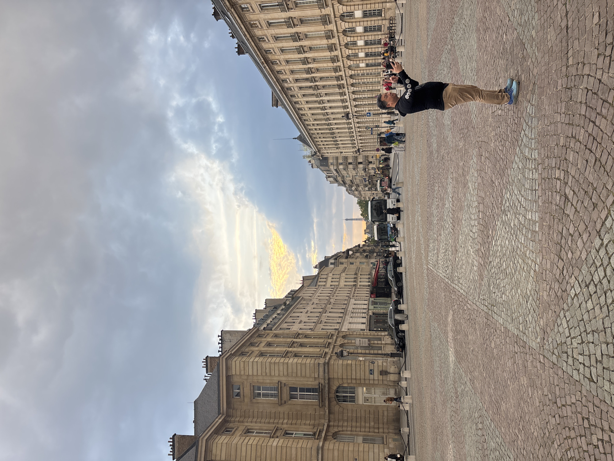 Tourist photographs Paris street scene with Eiffel Tower backdrop
