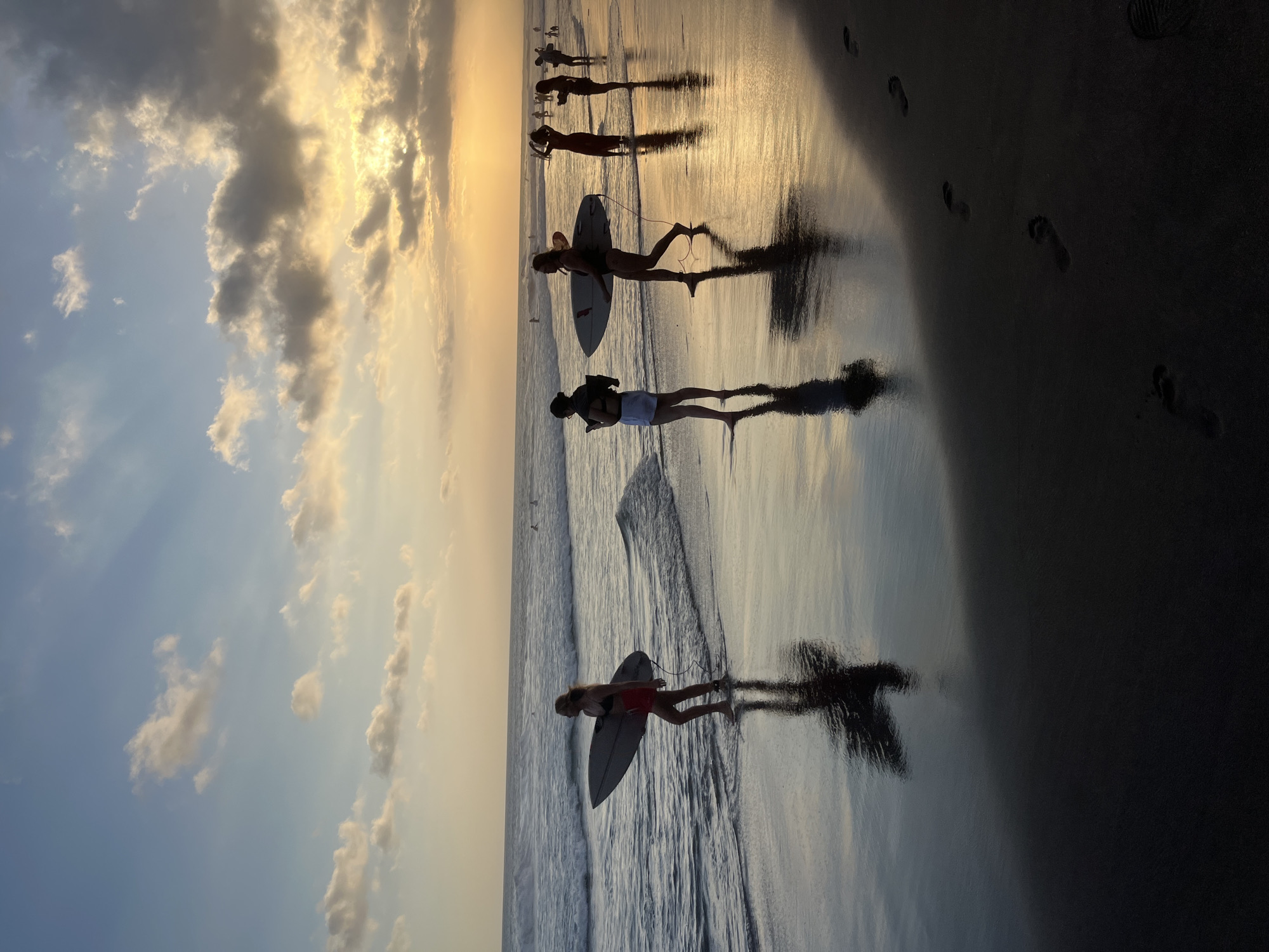 Sunset beach scenes with surfers and musician captured in Bali