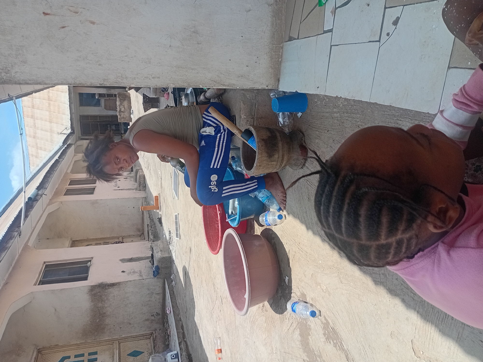 Family bathing activities documented in Lokoja residential courtyard