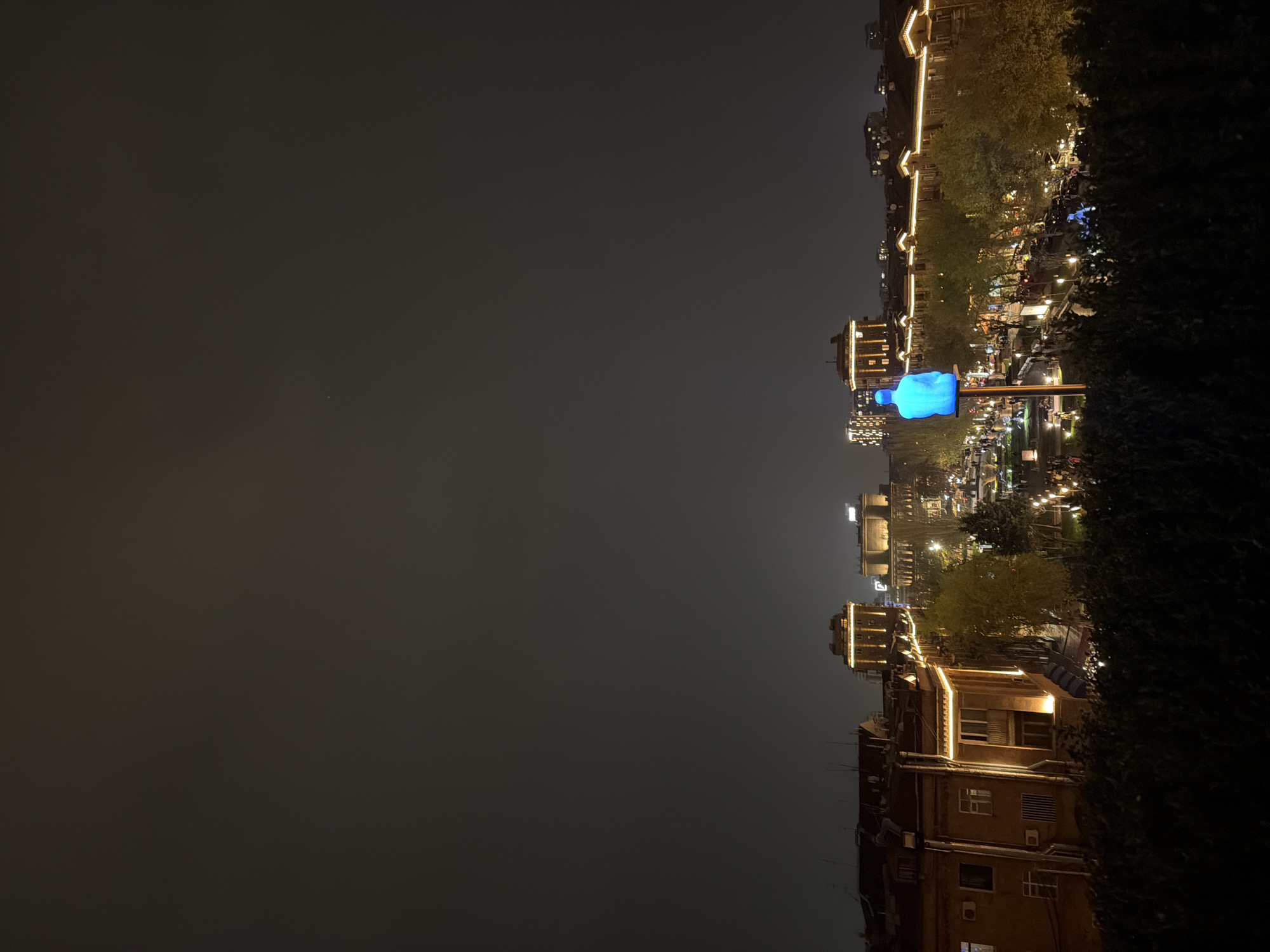 Evening street scene captured in Yerevan with illuminated sculpture