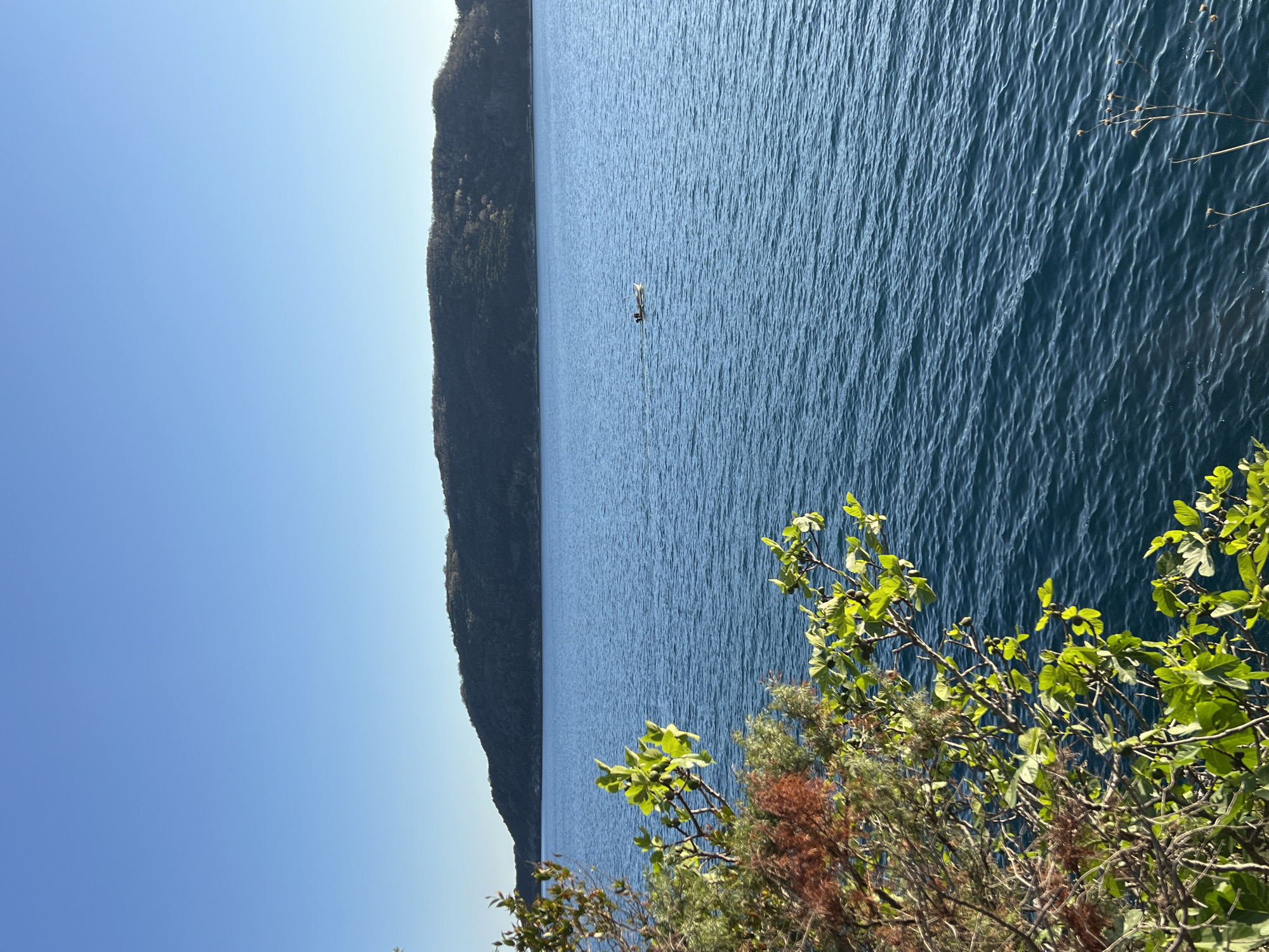 Woman watches lone paddler from Budva waterfront