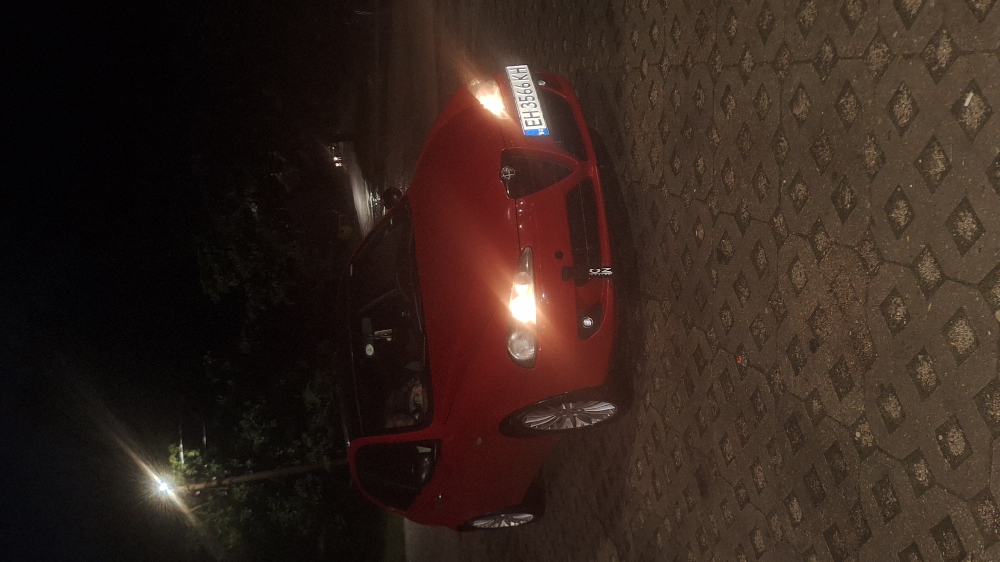 Parked car and shop window at night, July 2026