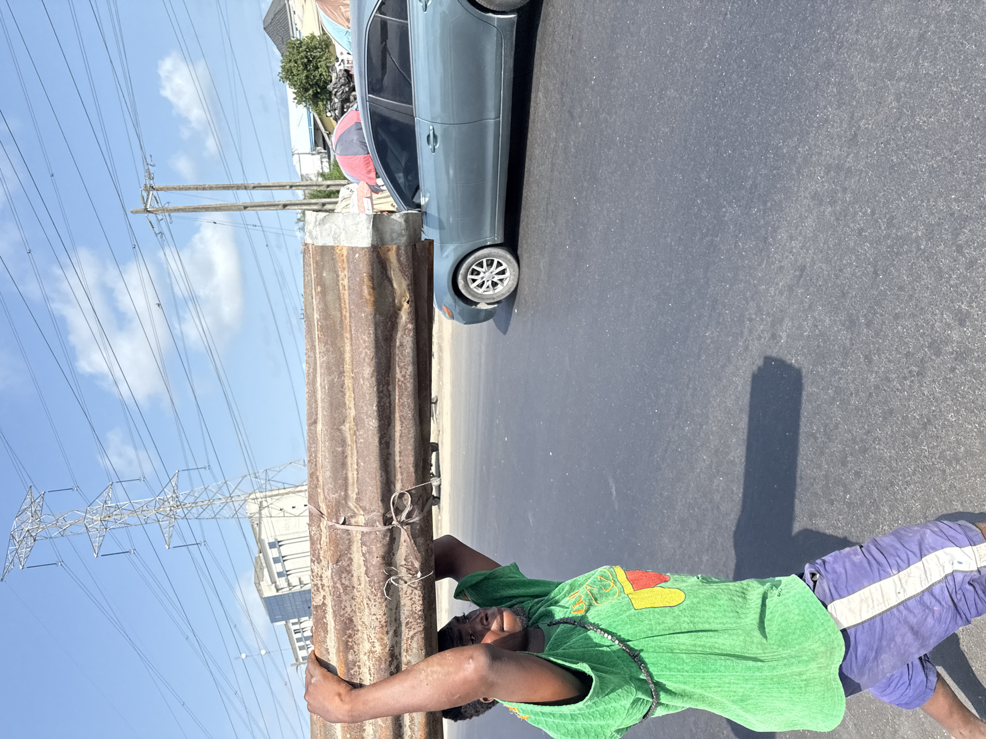 Man carries metal sheet in Igboefon, Nigeria