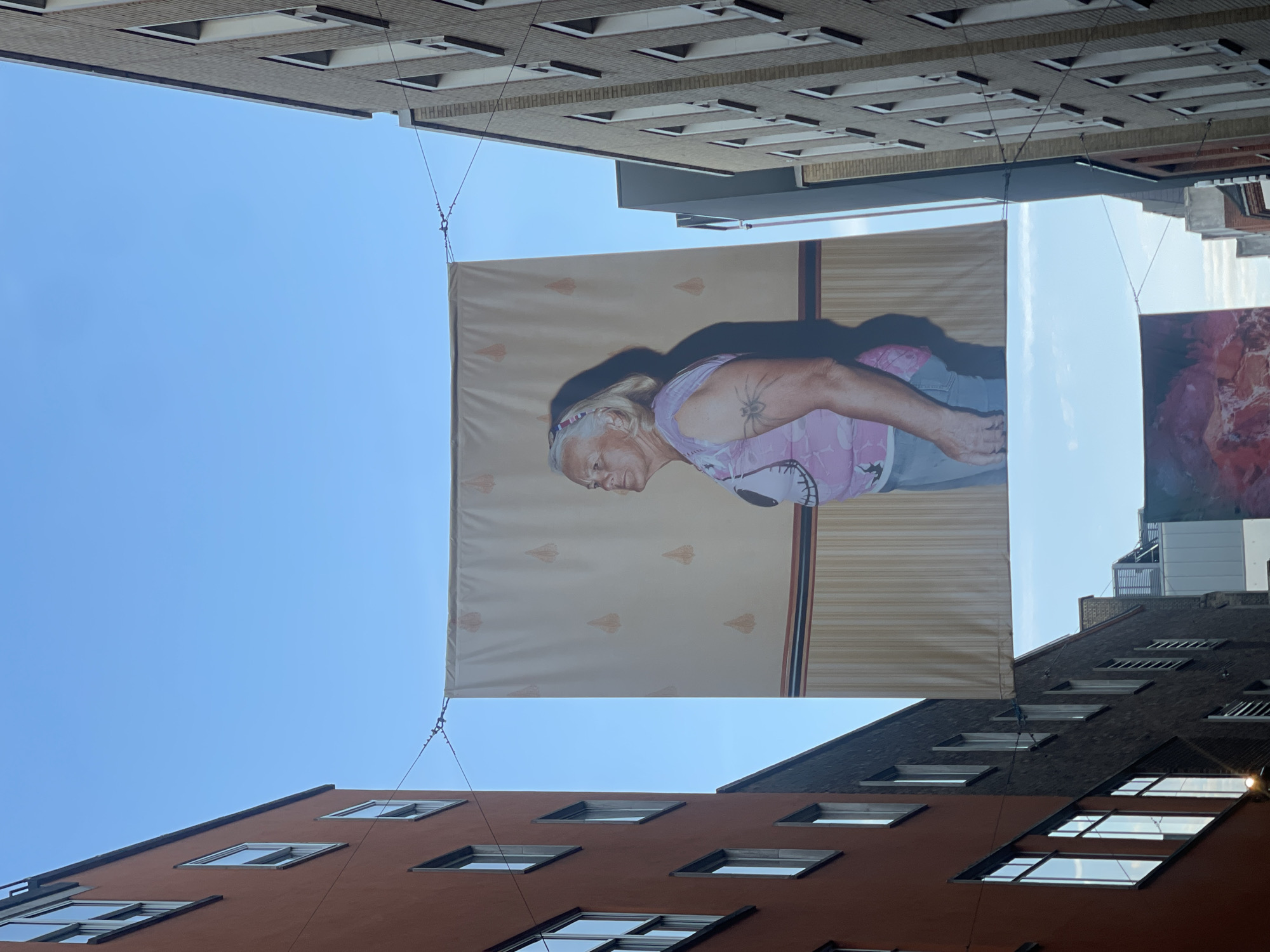 Large portrait banner with spider tattoo displayed in London