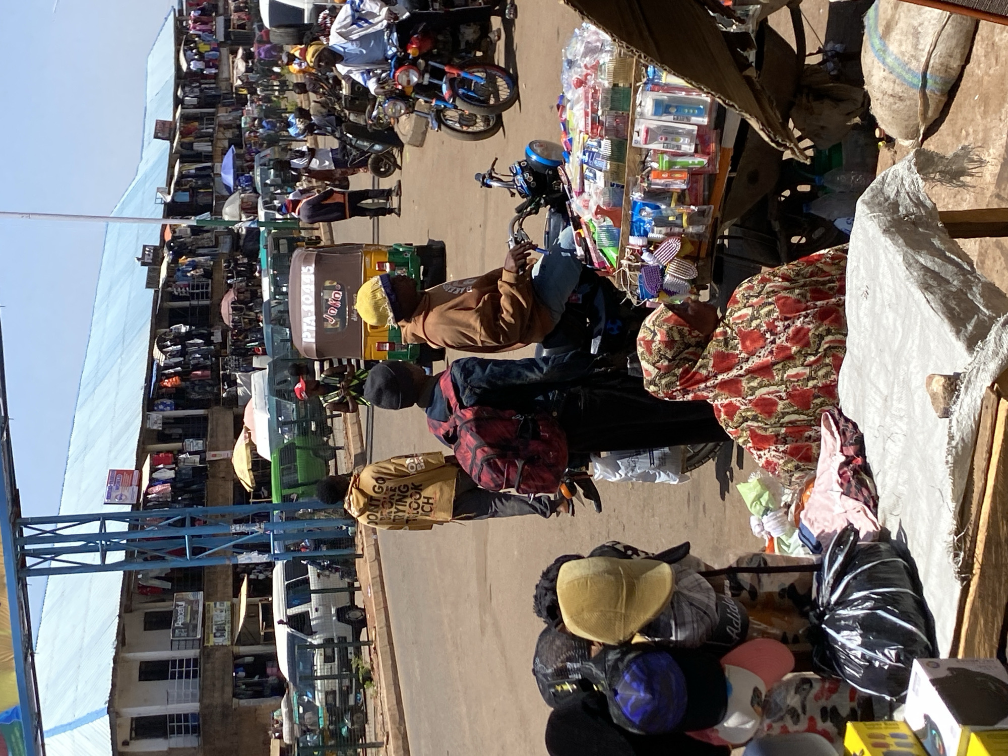 Morning marketplace bustles with vendors, motorcycles in Bukuru, Nigeria