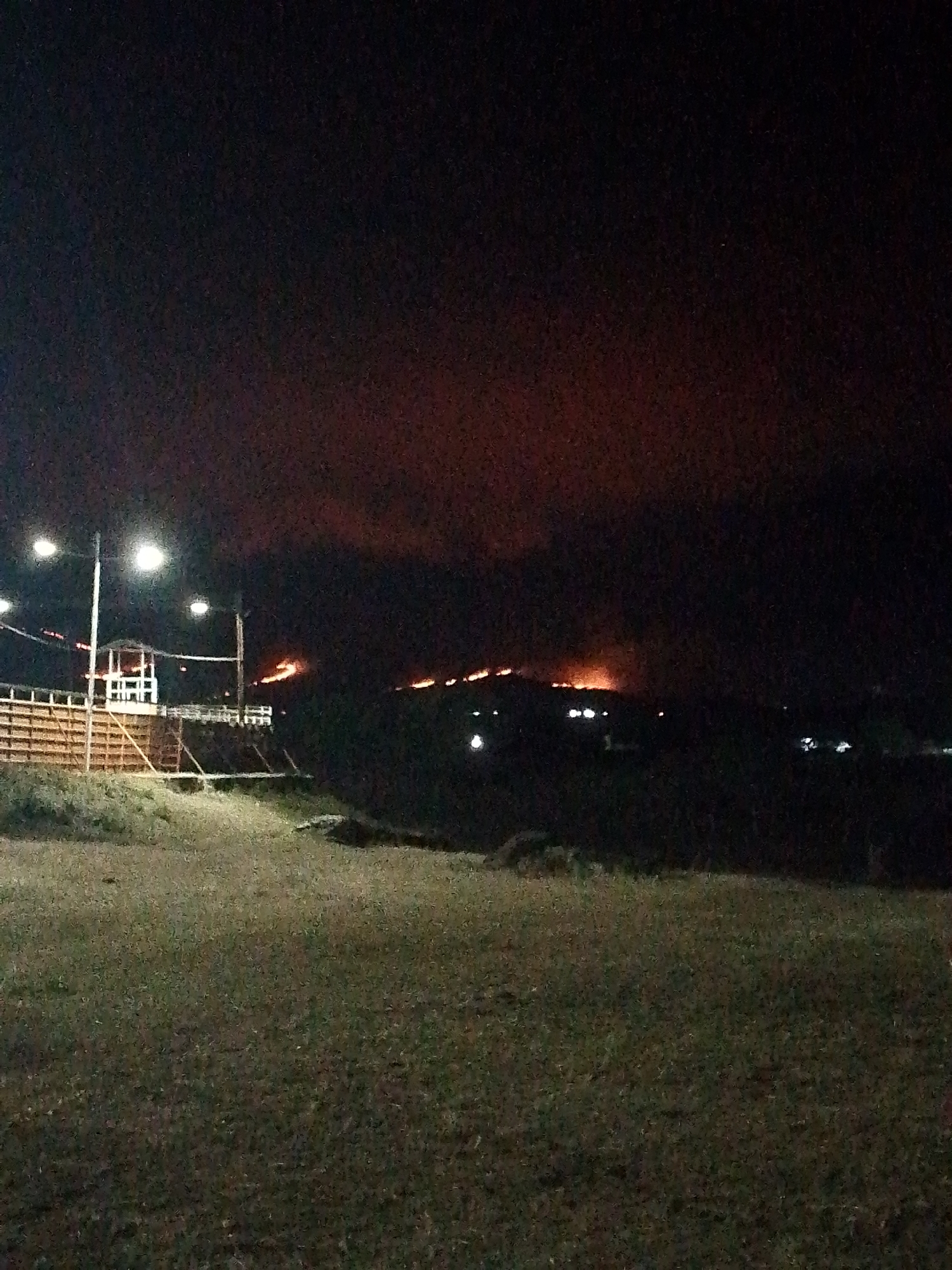 Hillside fire burns as crowd gathers at night event