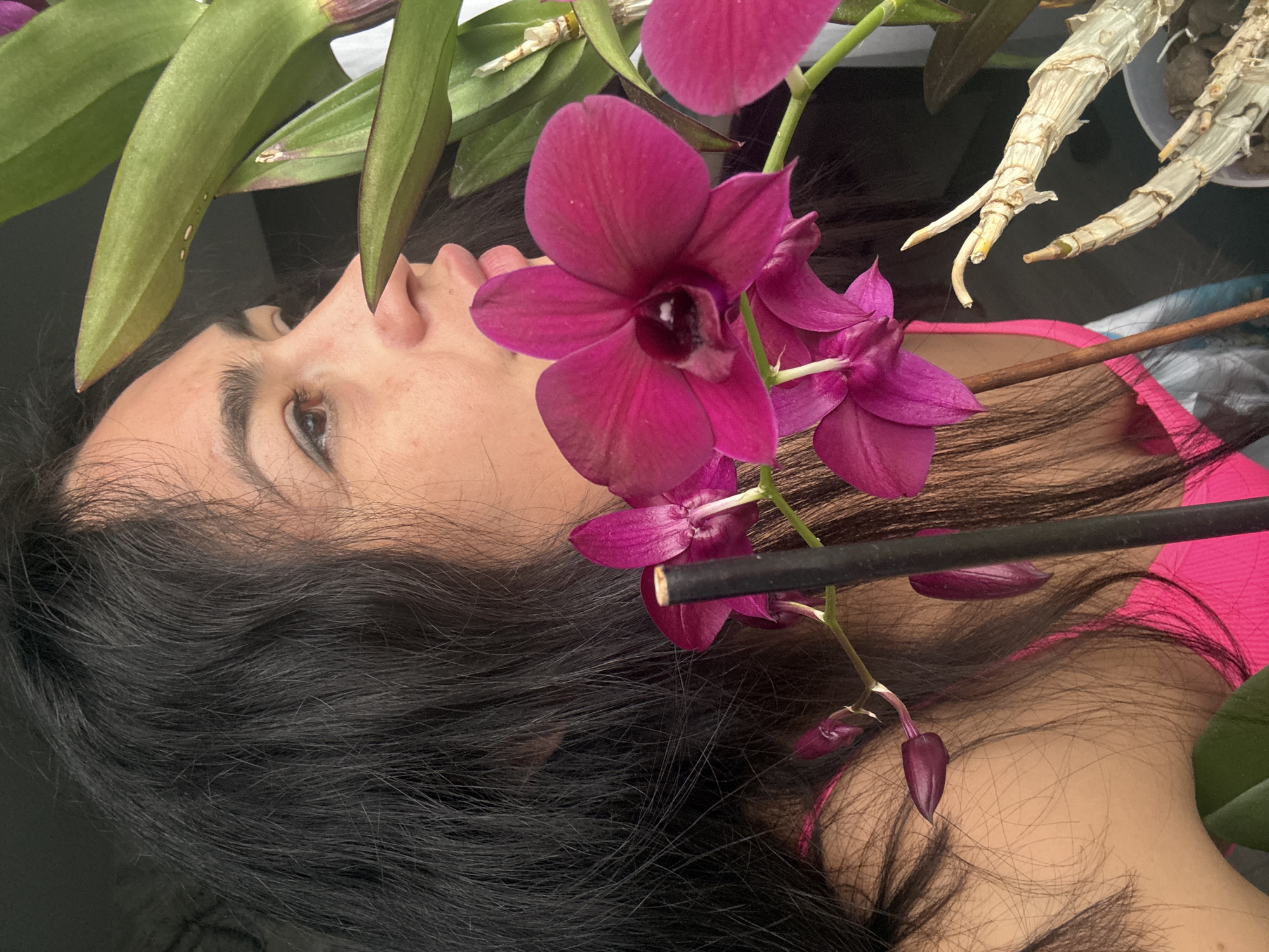 Woman enjoys pizza among orchids in Russian home