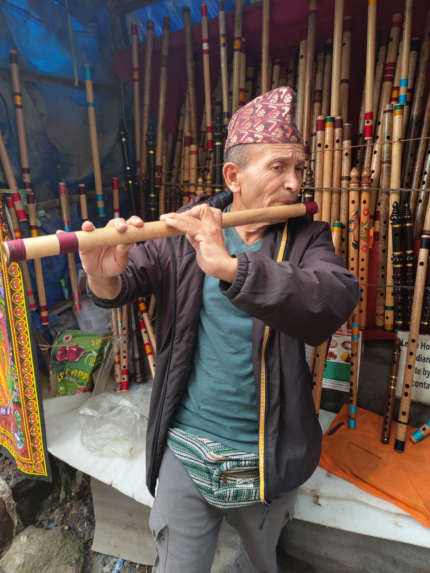 Street musician plays flute in Dharamkot, India