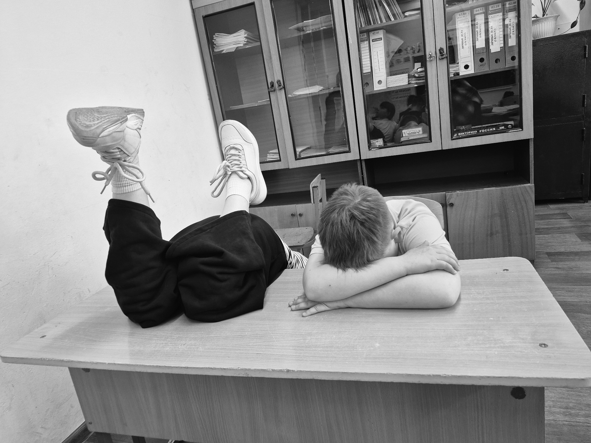 Boy photographed resting on desk in Chaikovsky, Russia