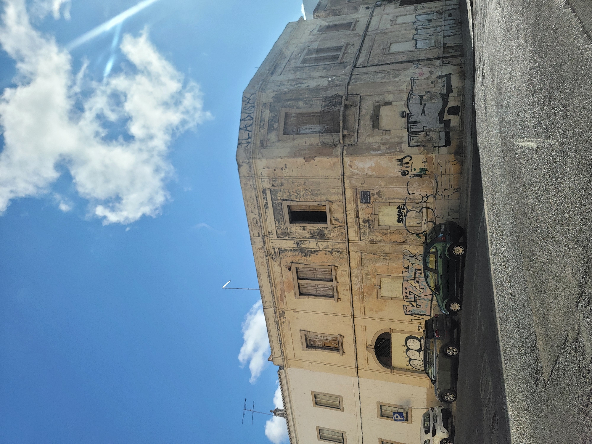 Street-level Faro: graffiti walls, parked cars, and local architecture
