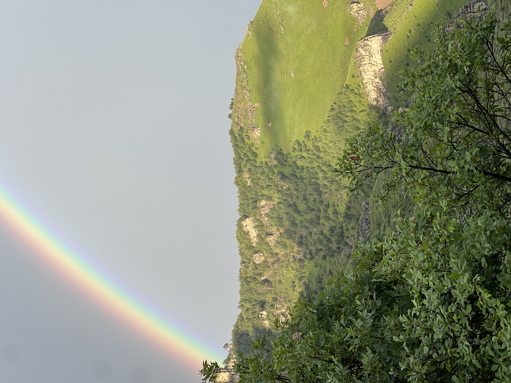 Double rainbows over a misty Caucasus mountain village