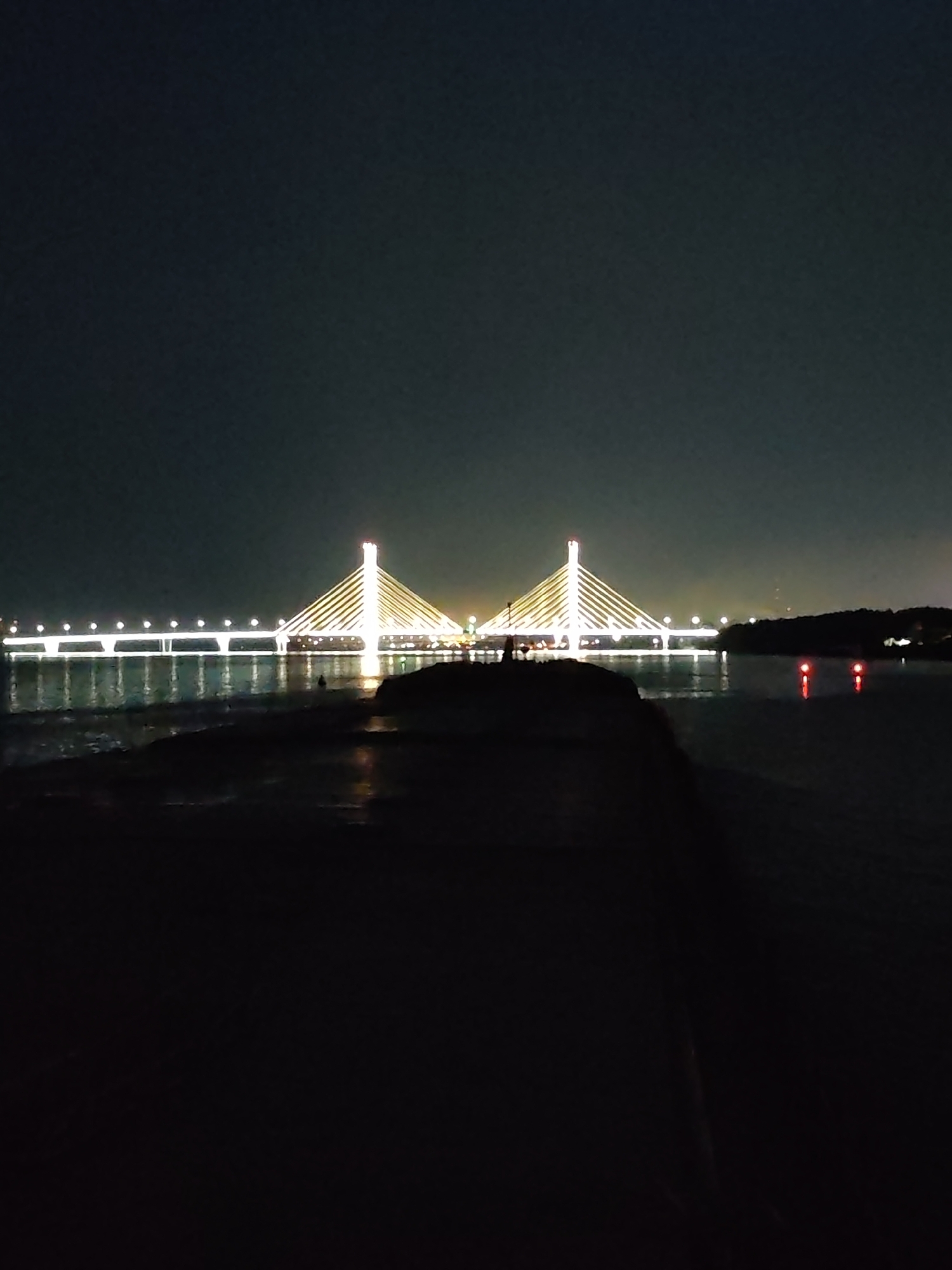 Nighttime views of an illuminated suspension bridge over water