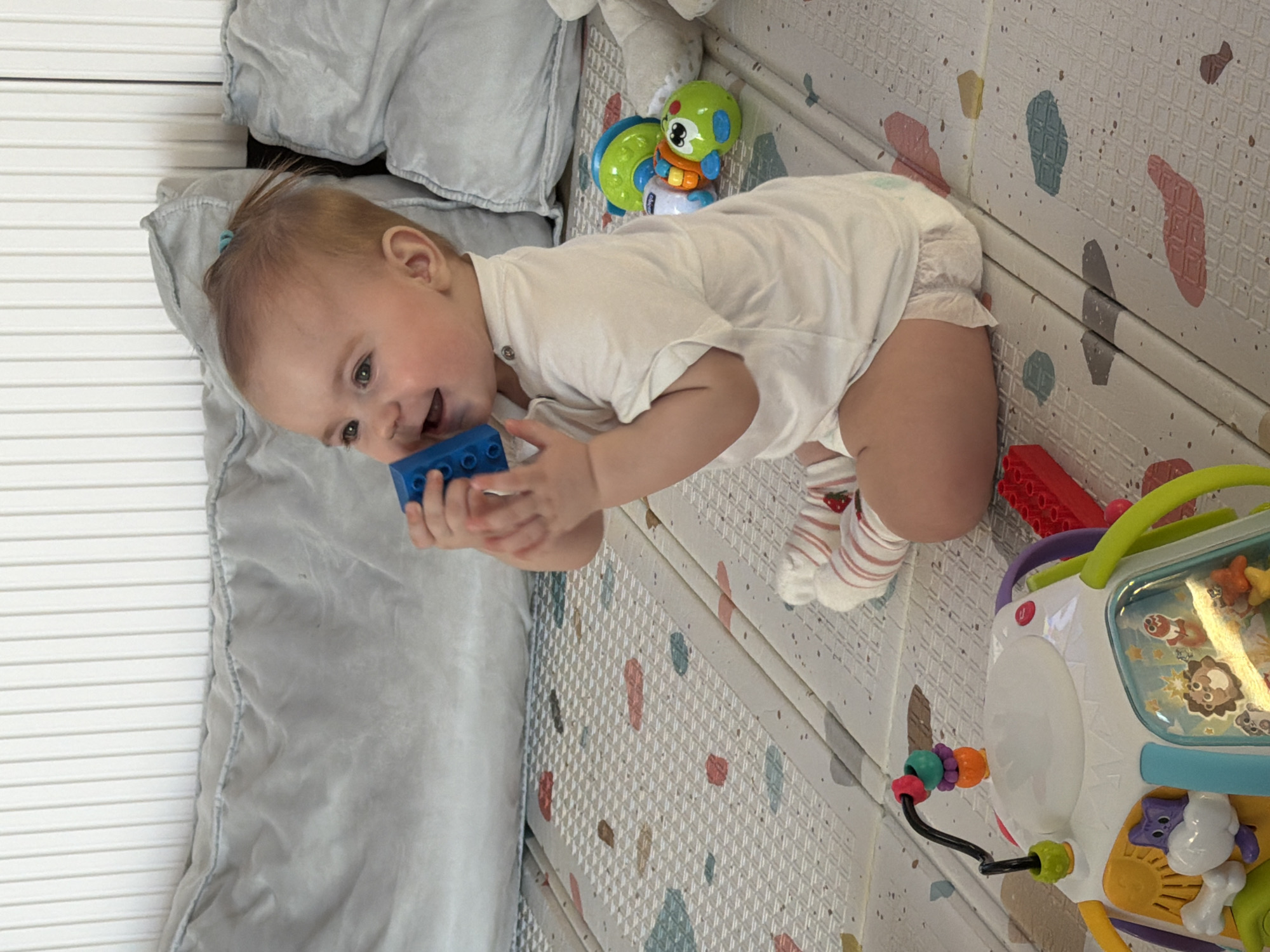 Baby plays with blocks on mat in Krasnoyarsk