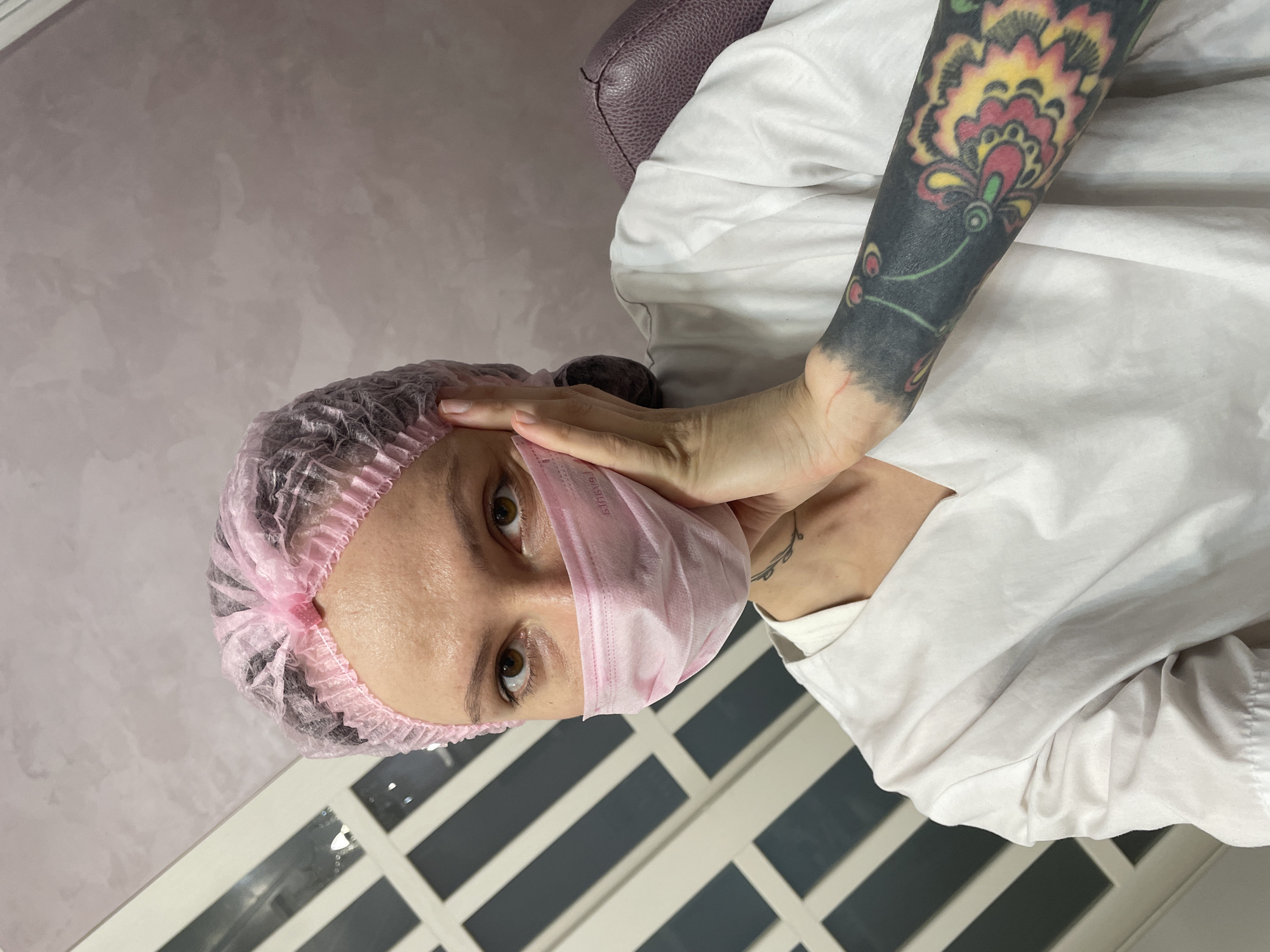 Woman in pink medical gear observed indoors in Izhevsk