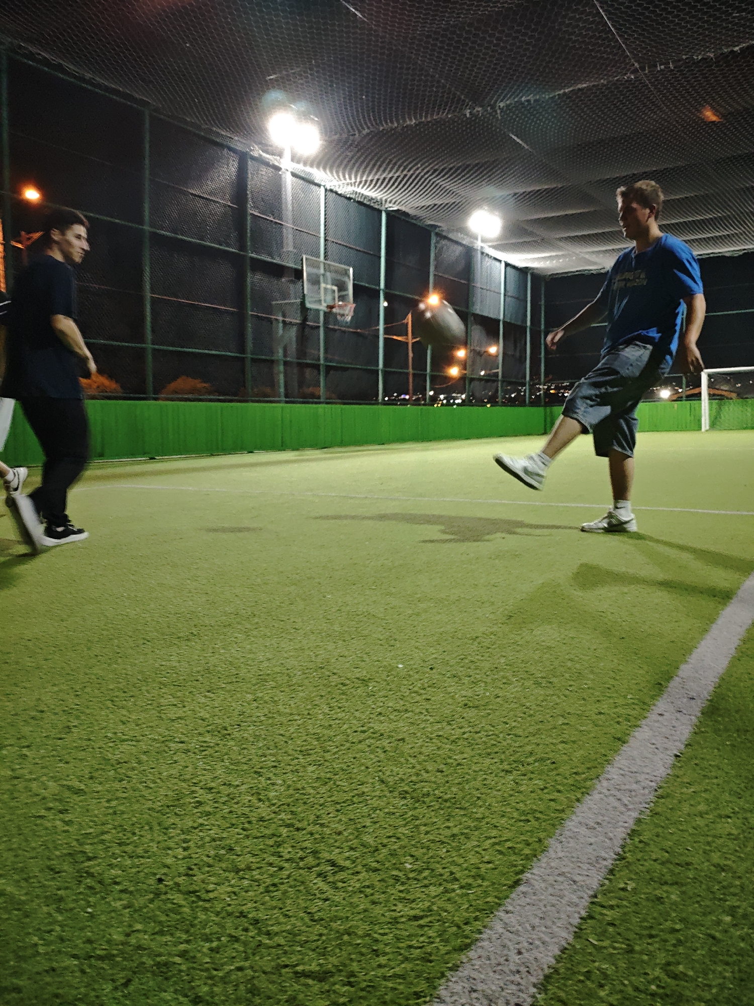 Late-night turf soccer session with a watch detail on the side