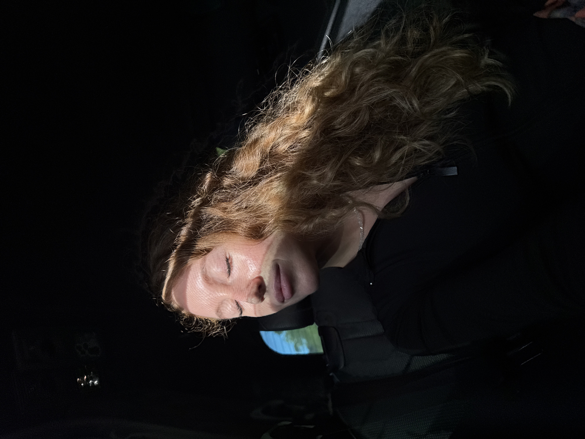 Woman rests in vehicle back seat in Kialasur, Abkhazia
