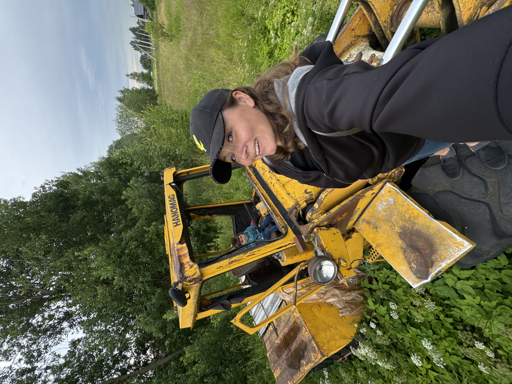 Kid behind the wheel of a rusted Hanomag loader in rural Russia