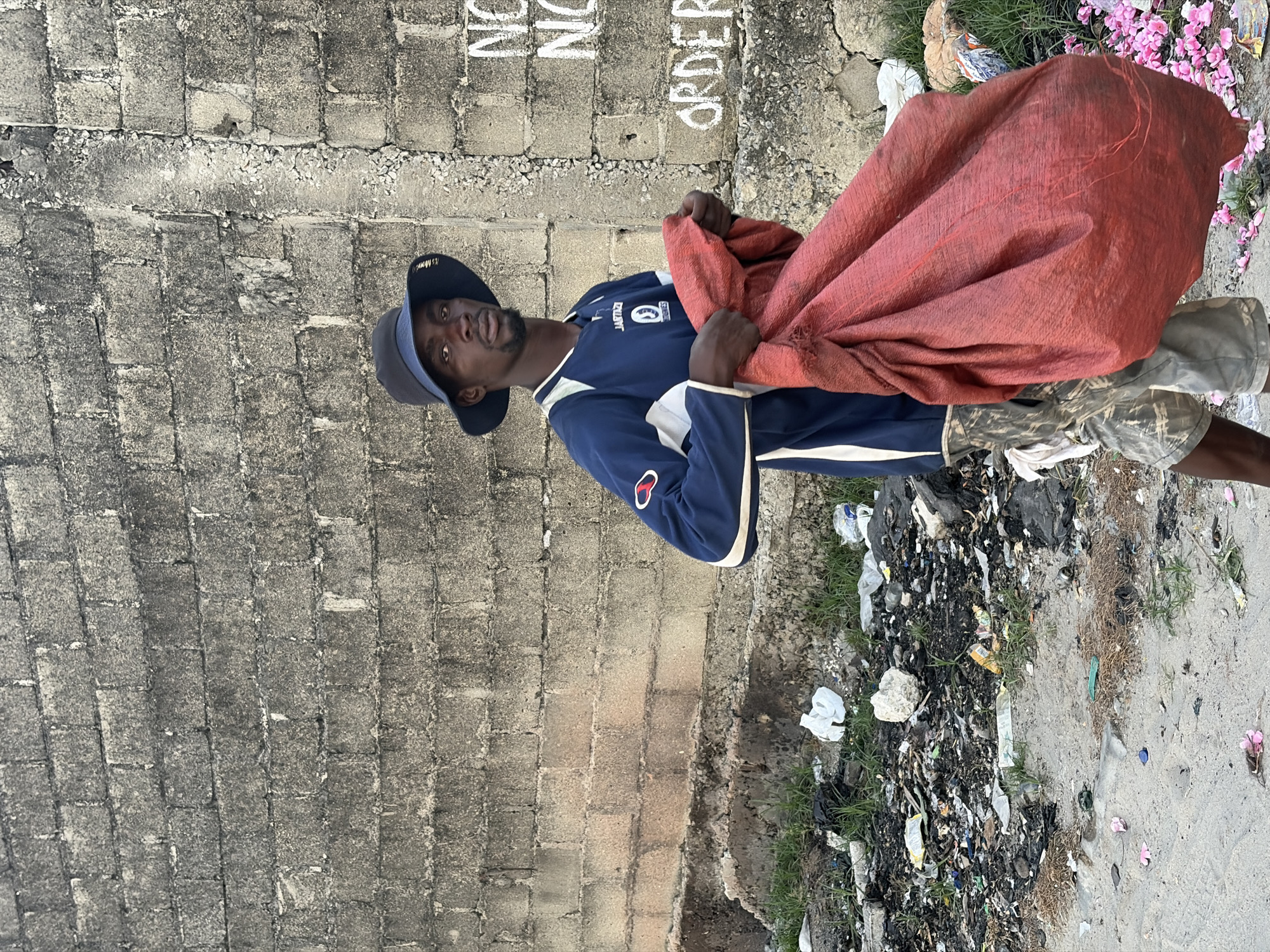 Man with red bag observed near graffitied wall in Alaguntan